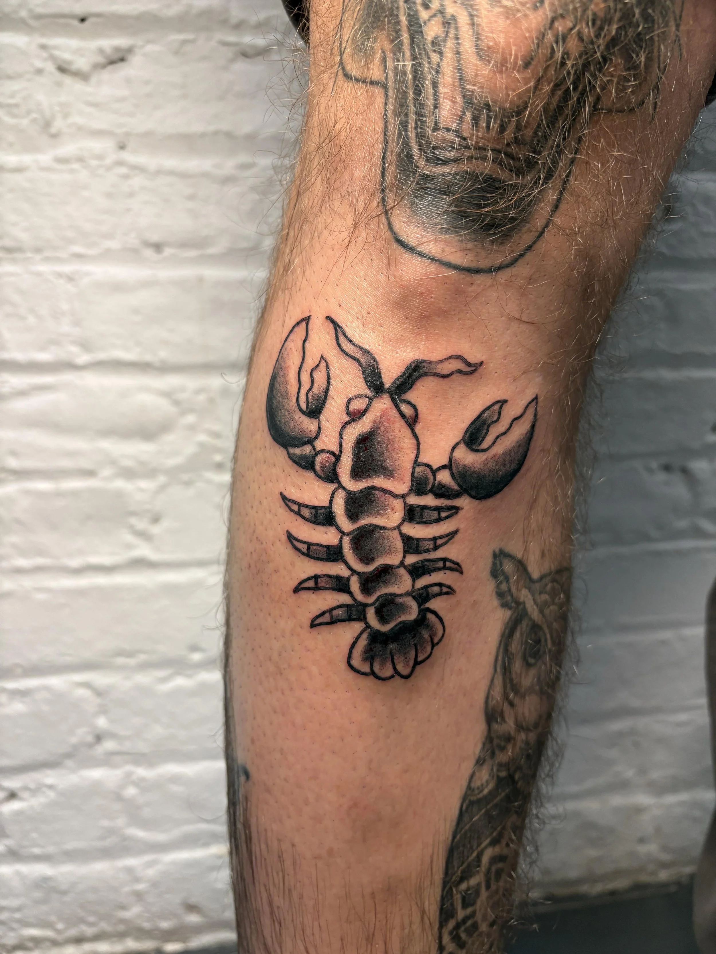 american traditional tattoo of a lobster in black and grey ink 