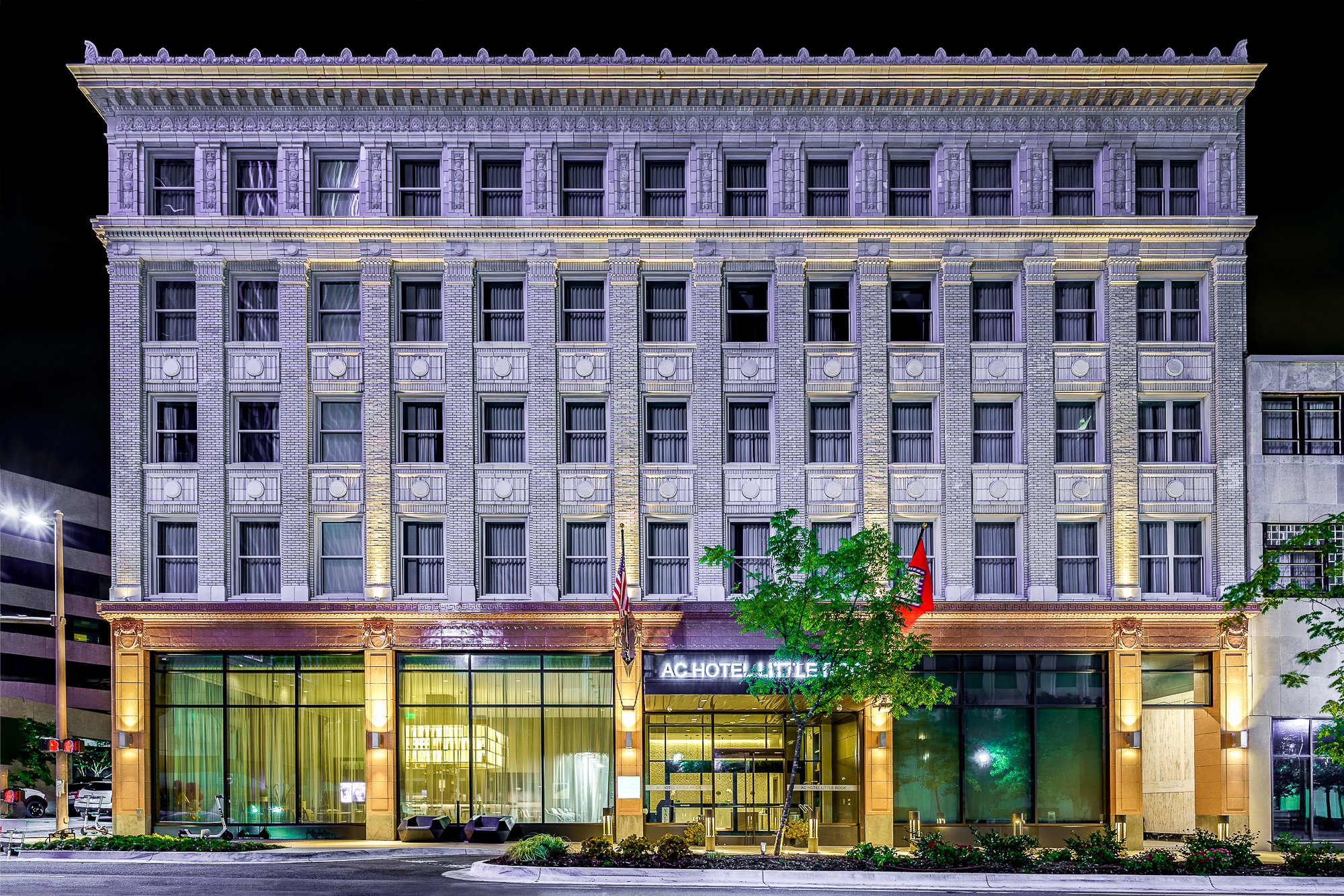 Historic building facade at night with large windows and decorative elements.