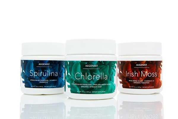Three containers of dietary supplements labeled Spirulina, Chlorella, and Irish Moss, from the brand Algenist, displayed against a white background.