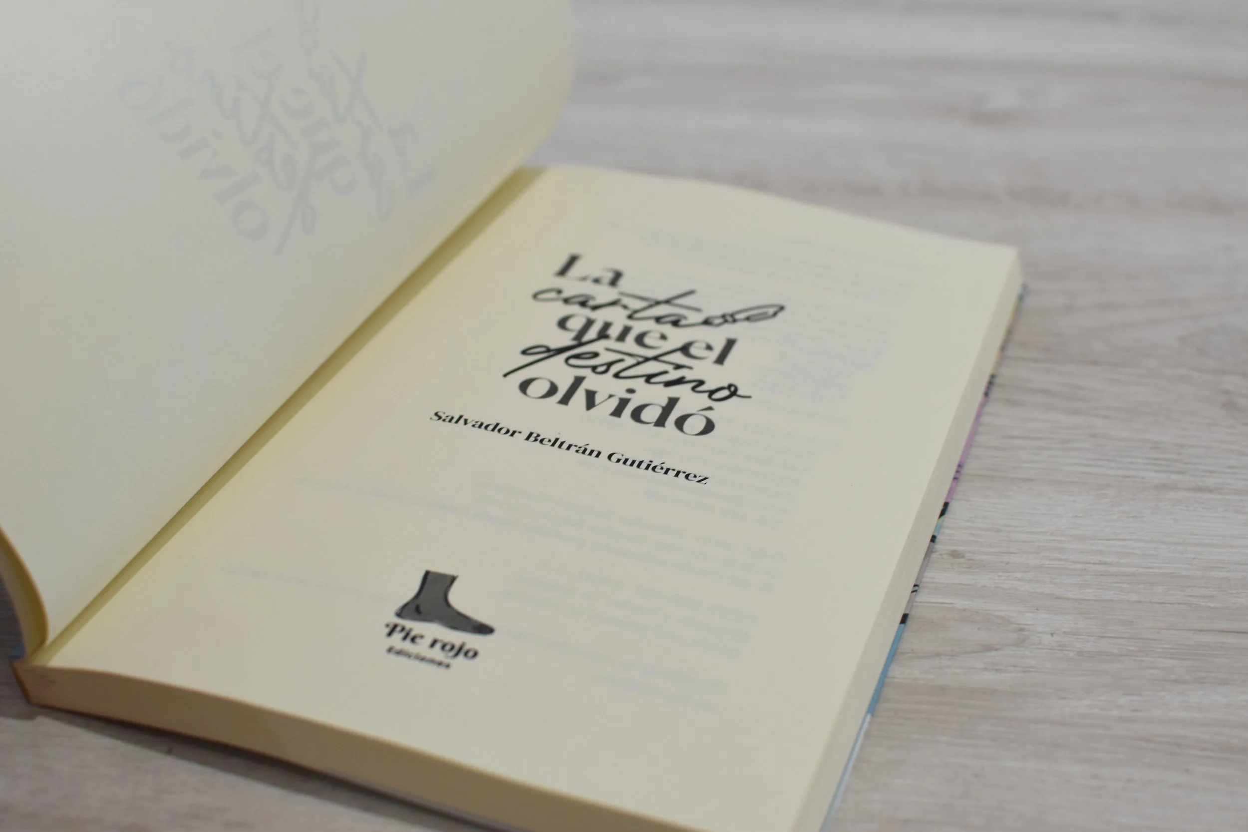 Página de un libro con el título 'La torta que el dejó olvidó' de Salvador Beltrán Gutiérrez, publicado por Pie rojo Editorial, sobre mesa de madera clara.