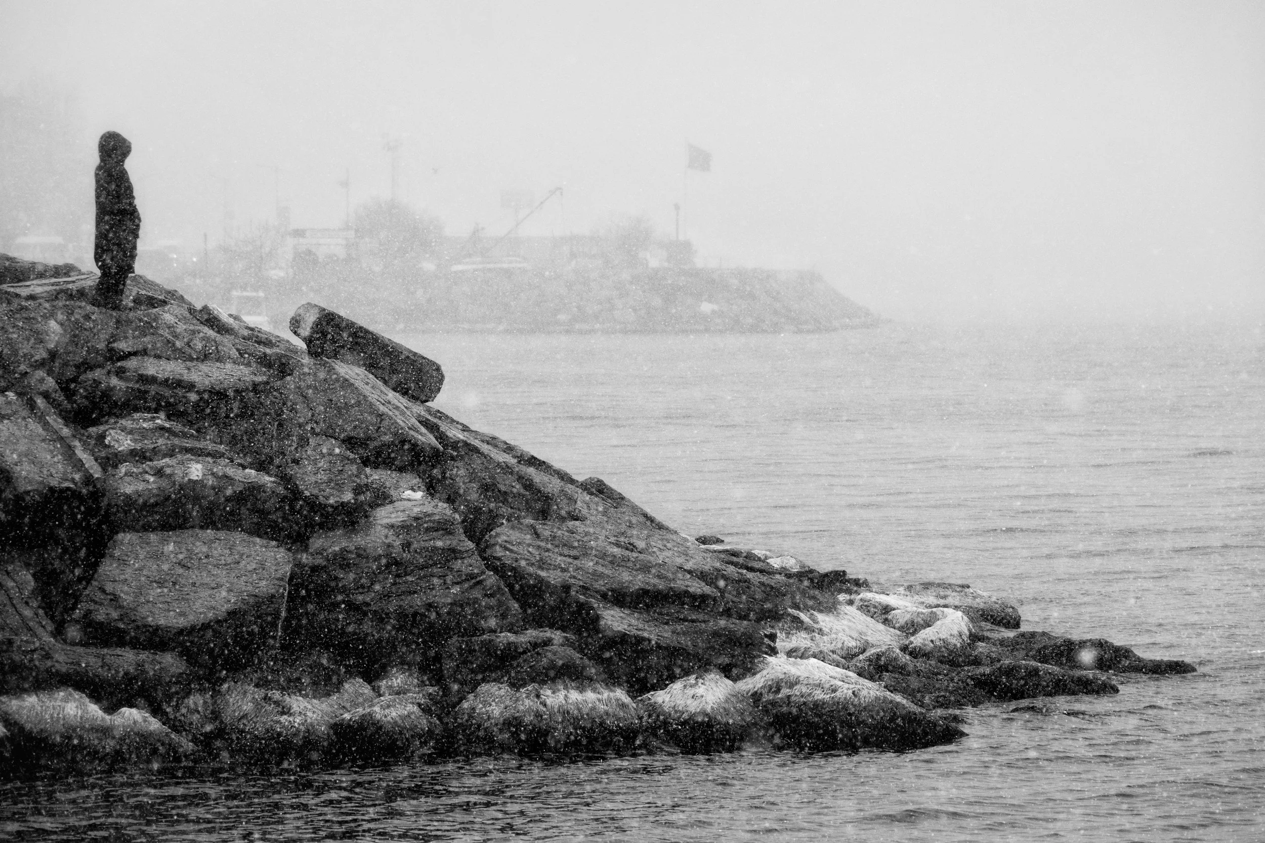 person standing on rocks in the rain might benefit from online therapy