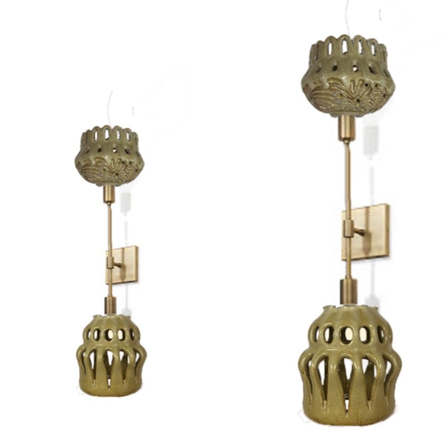 Two gold wall-mounted lamps with decorative perforated bases and ornate ceilings, positioned against a white background.