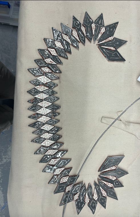 A circular arrangement of dominoes laid face down, with their faces showing various patterns, placed on a beige surface.