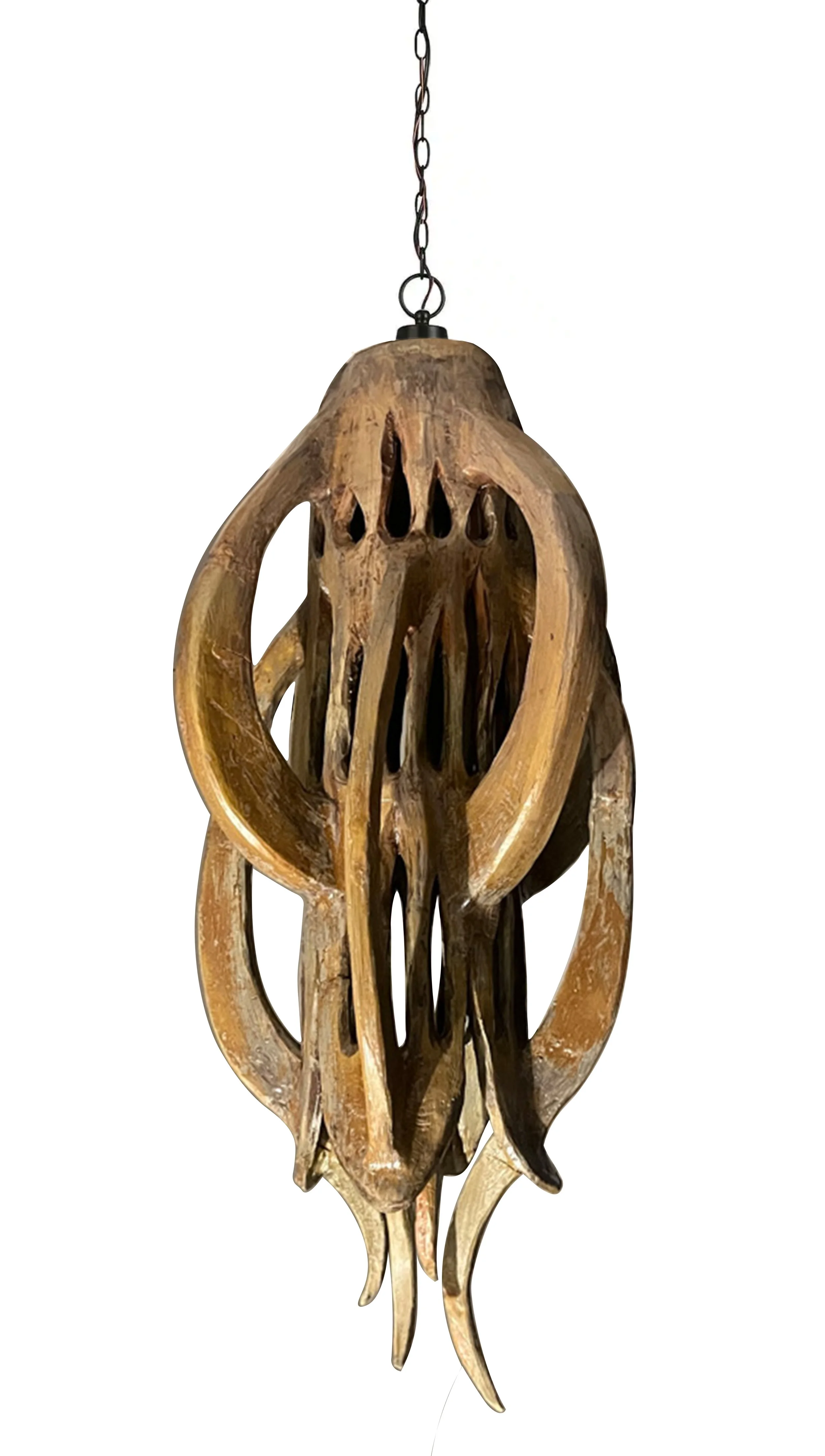 Hanging wooden sculpture resembling an abstract animal skull with elongated shapes and carved details.