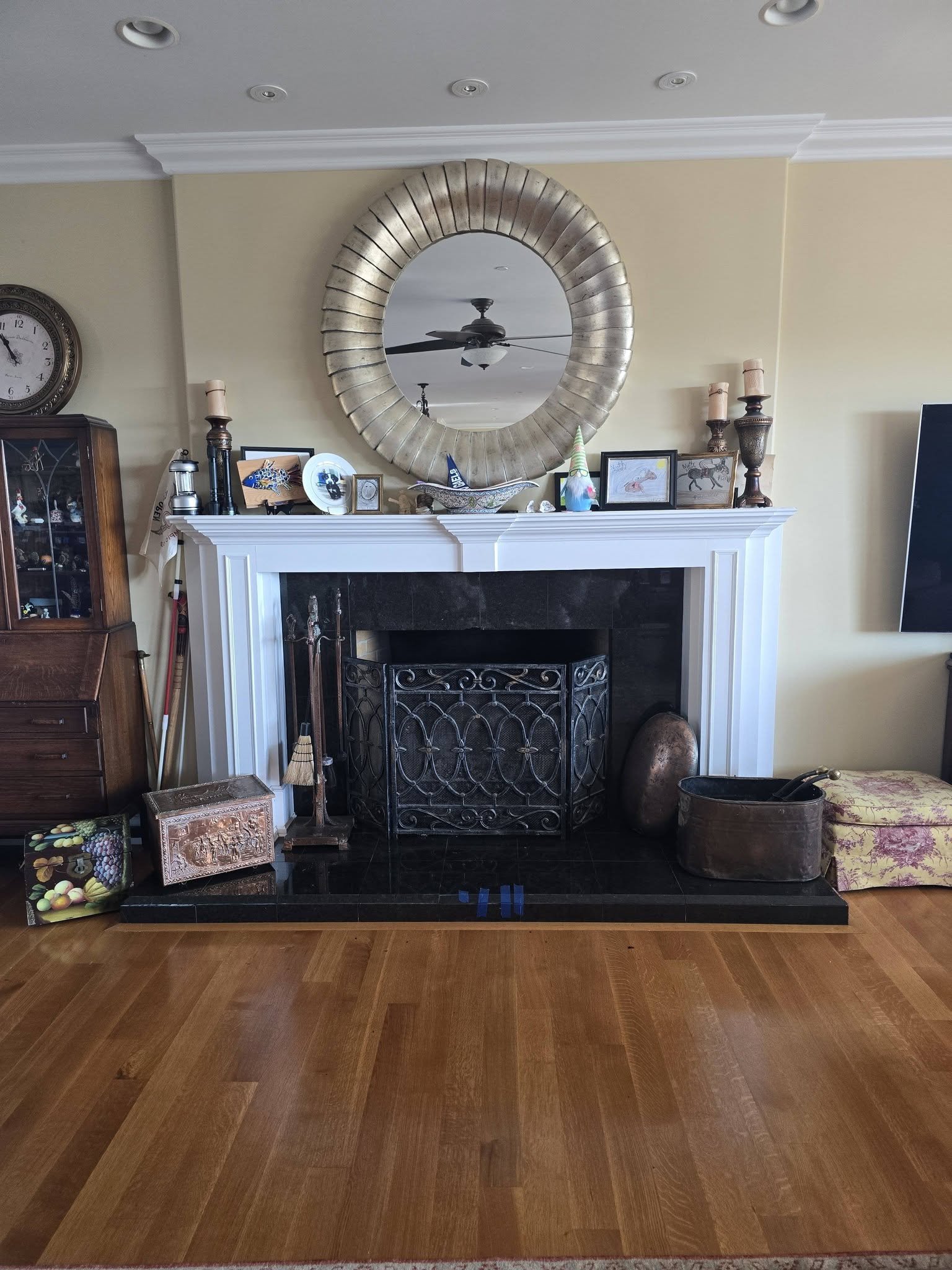 Outdated white painted wood mantle with black tile fireplace facade