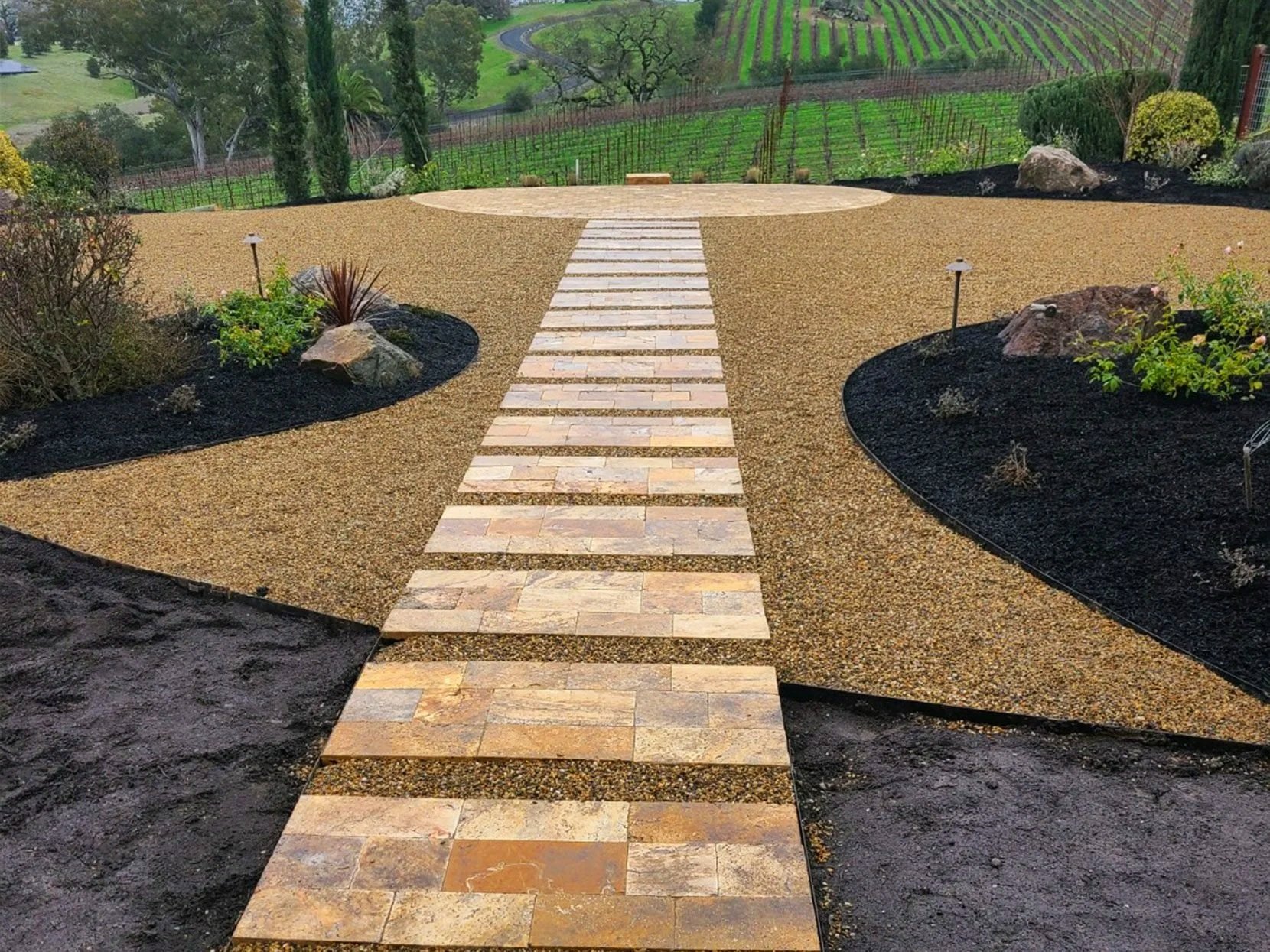 Sonoma county backyard with small gravel and pavered stepped walkway leading to pavered patio