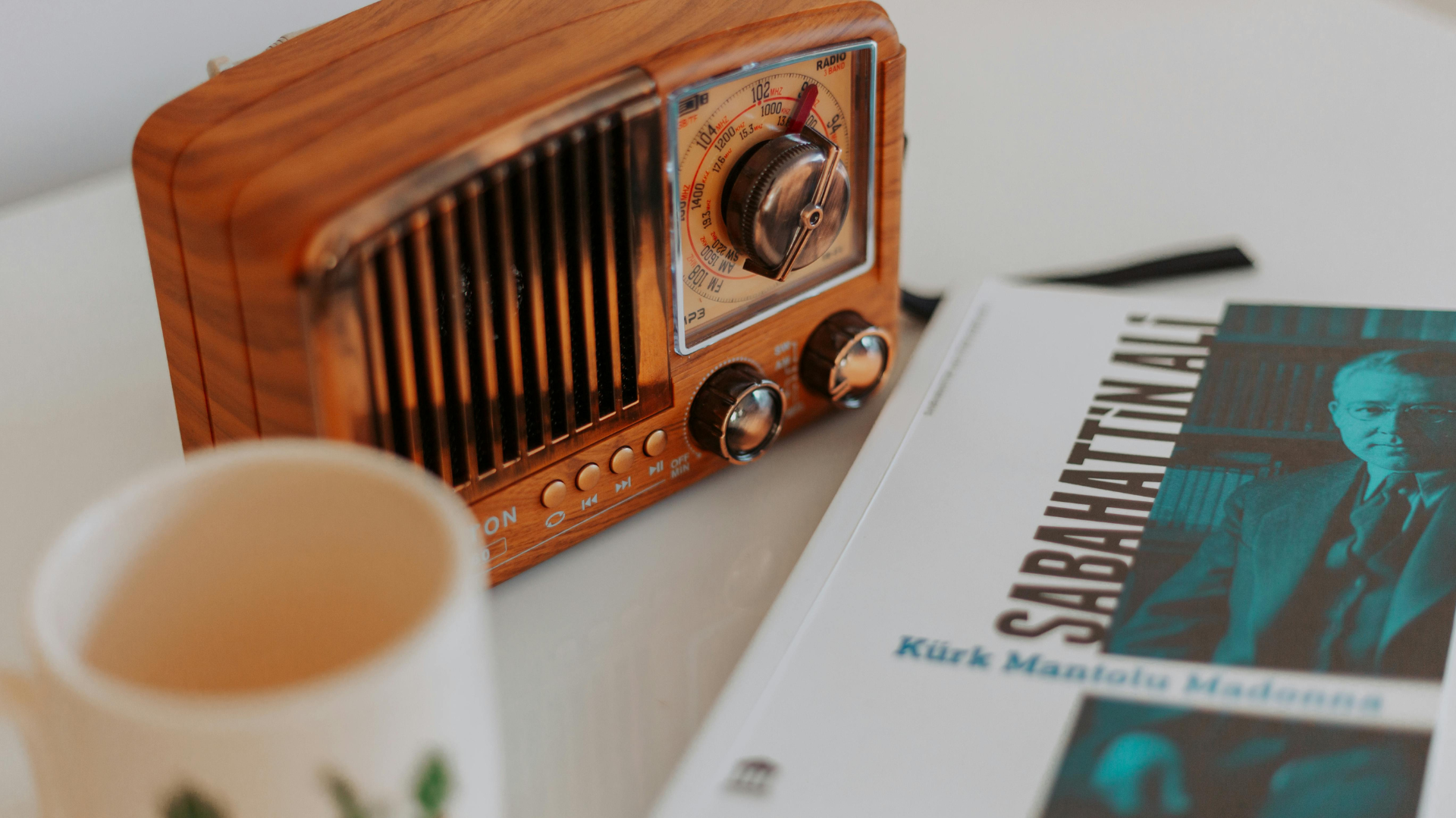 A close-up view of a desk featuring a radio with a magazine placed beside it.