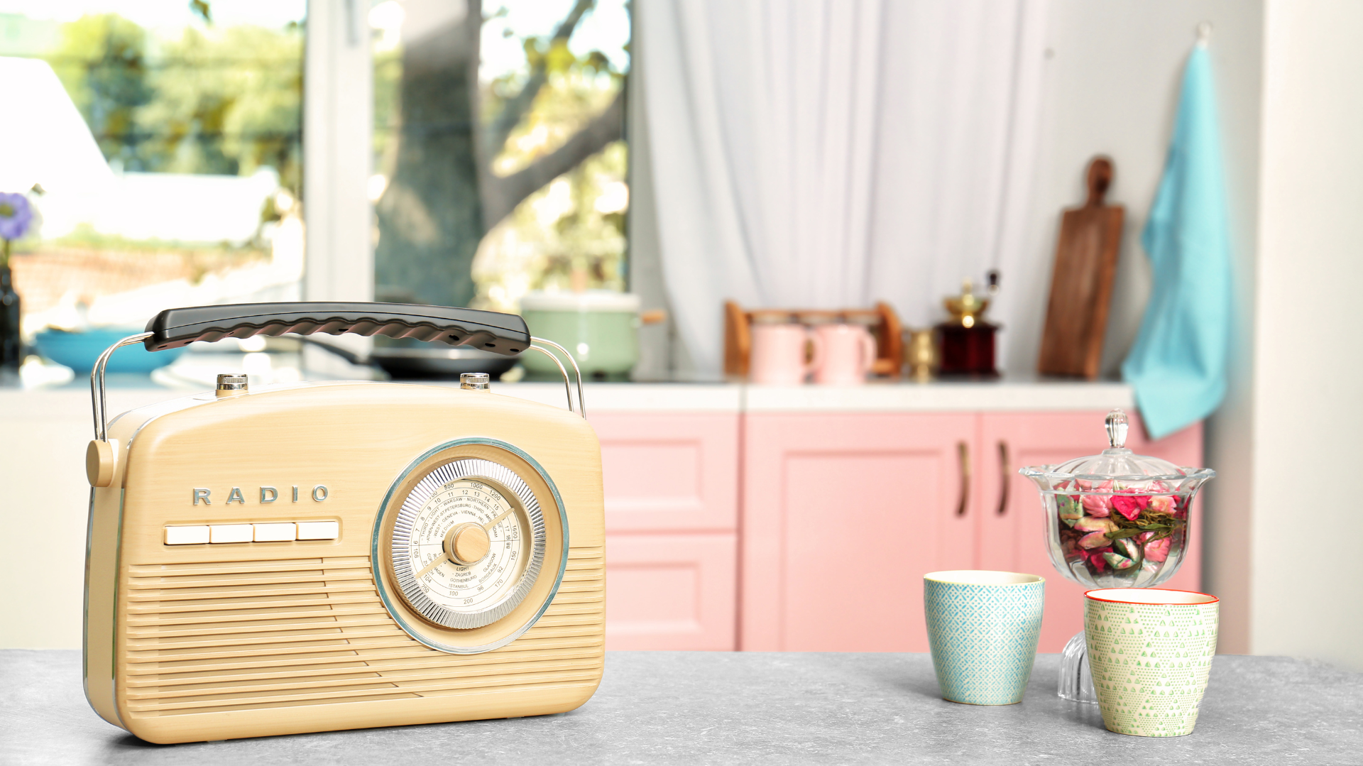 A radio on a kitchen countertop in a bright, home kitchen.