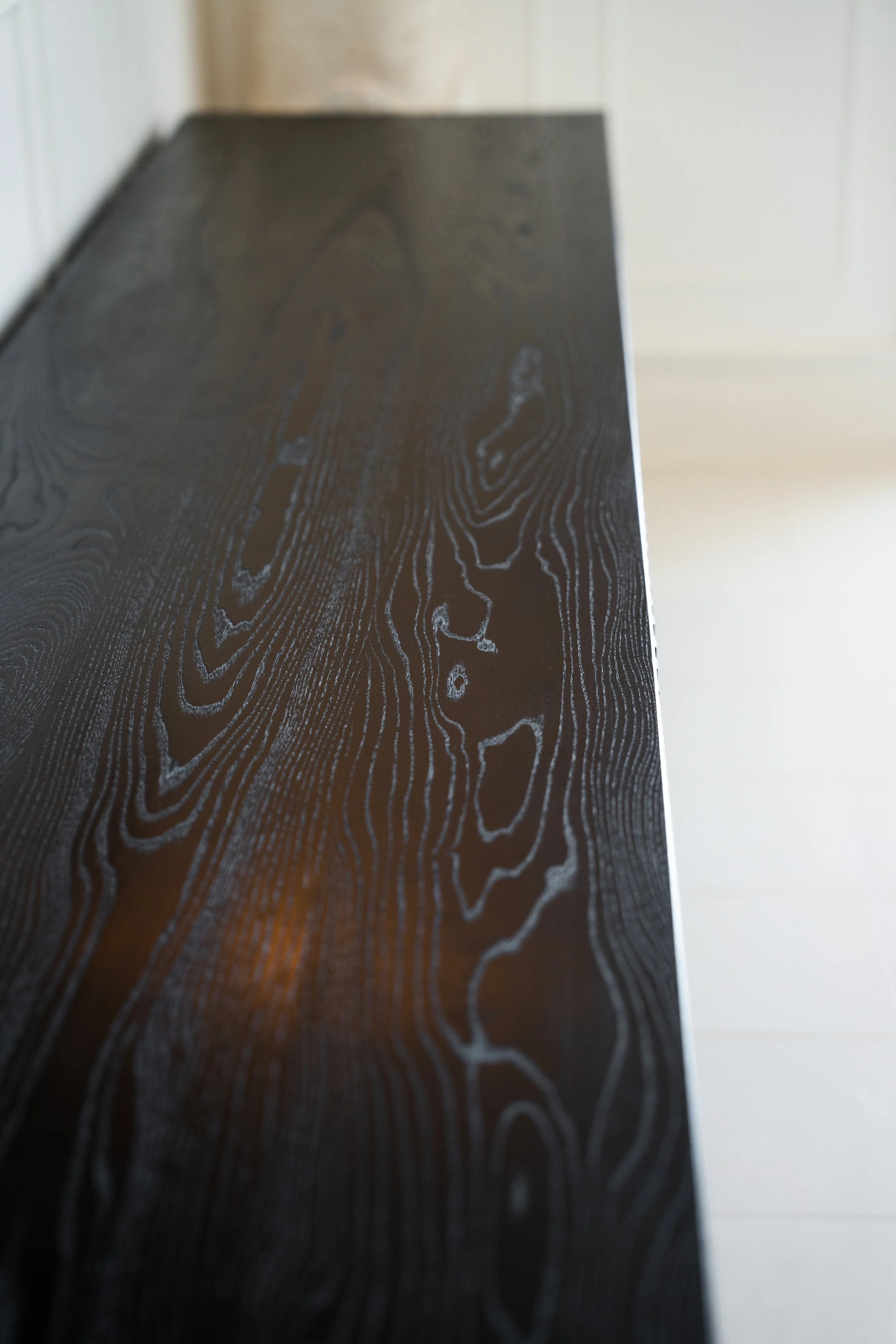 Close-up of a black wooden surface with natural wood grain patterns.