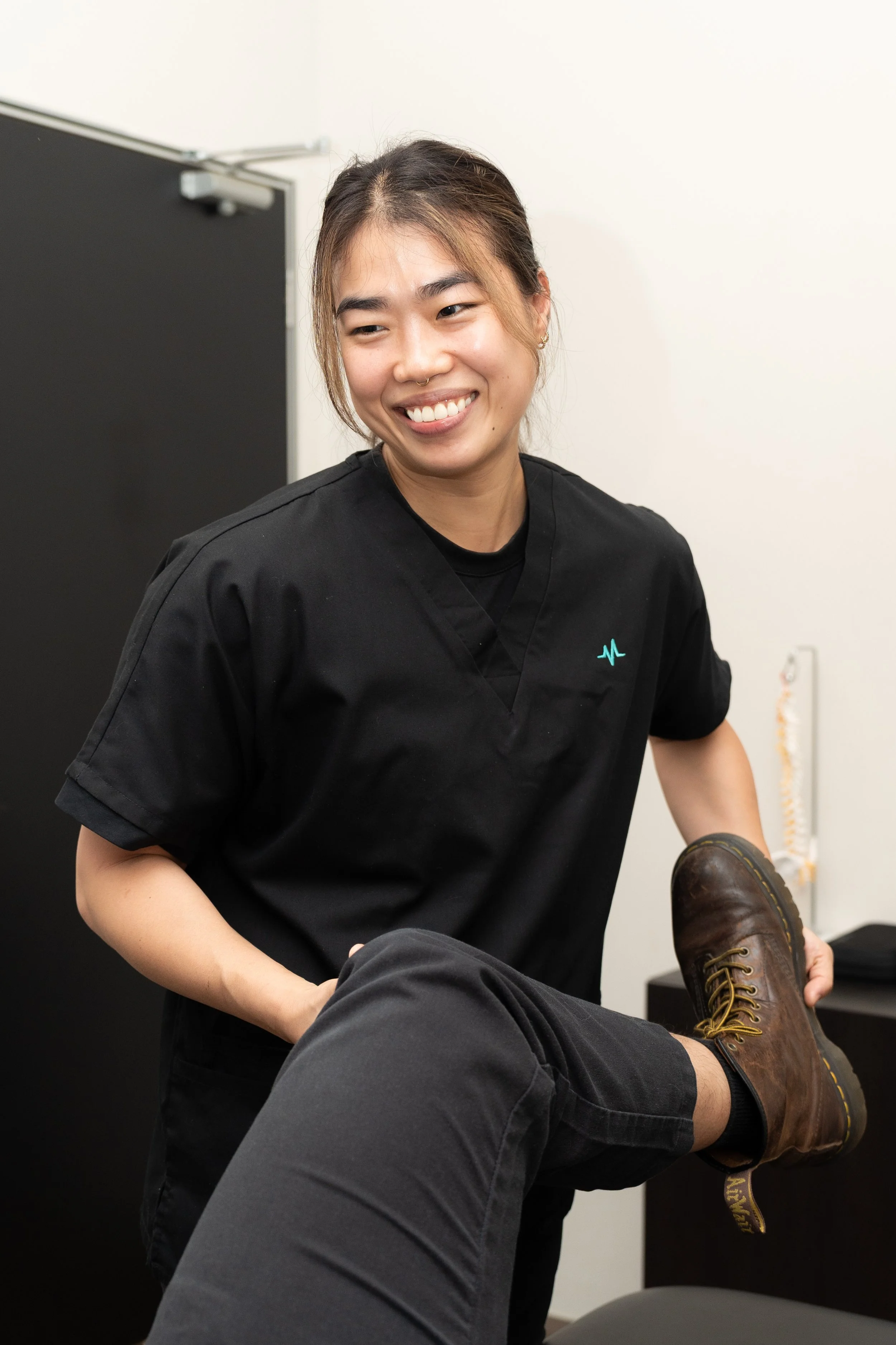 MoveMed physiotherapist guiding a patient's bent knee during a treatment session