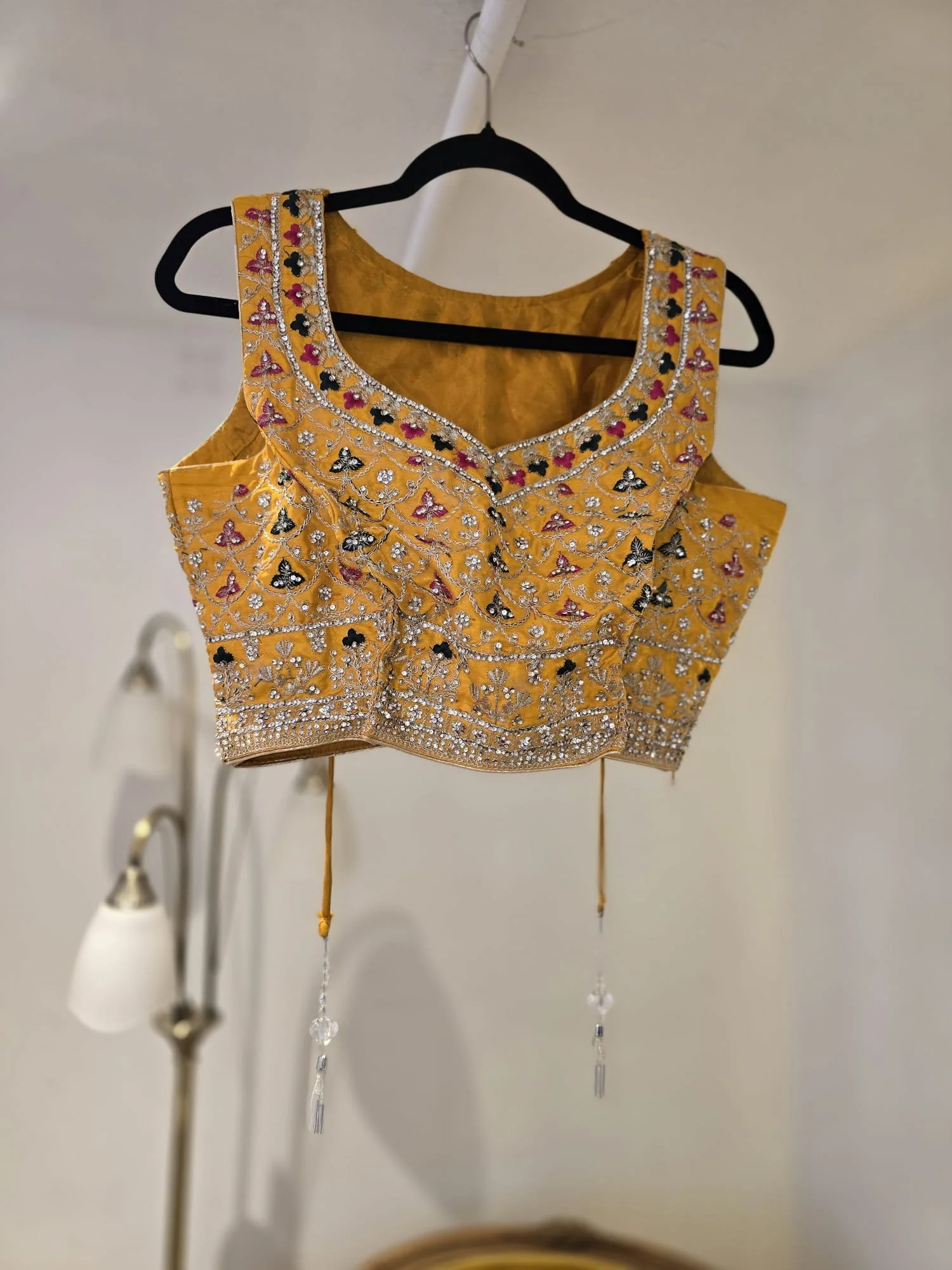Mustard yellow silk Indian blouse with colourful embroidery and mirrorwork, shown before fitting adjustments at Brighton Alterations.