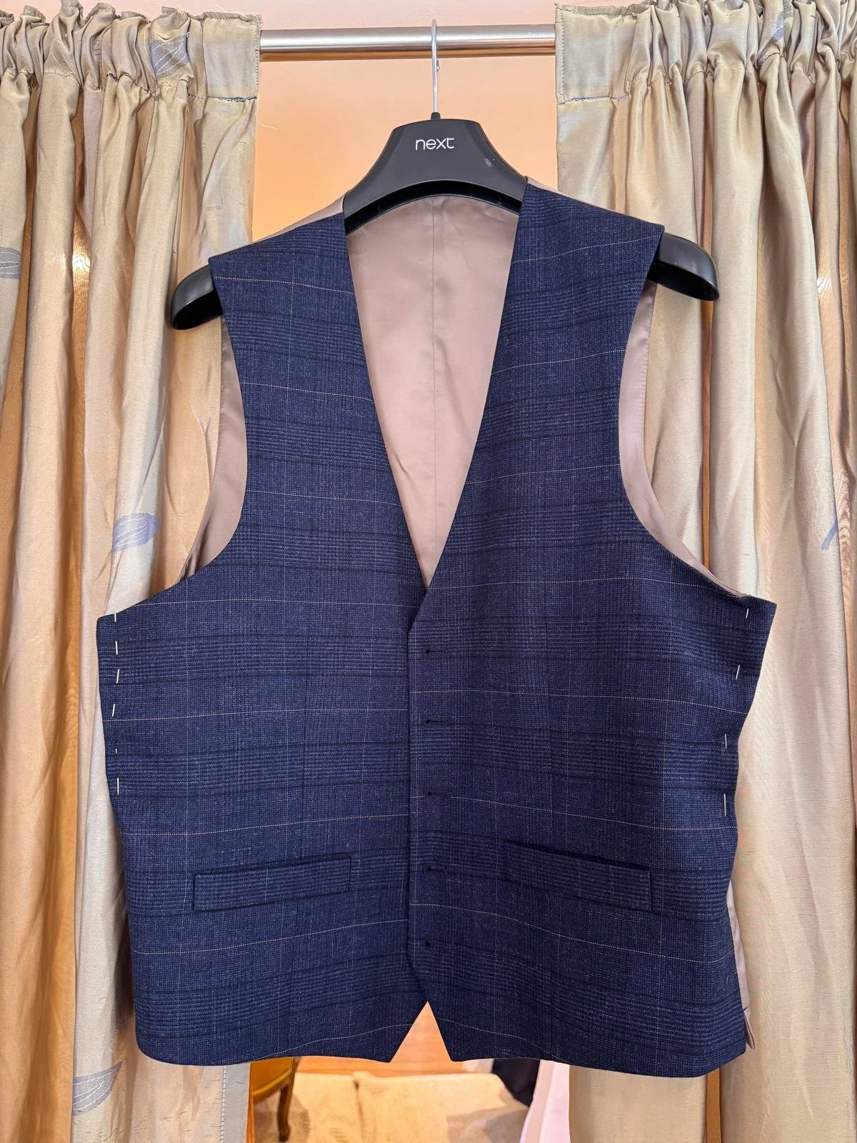 A pinned navy check waistcoat in soft wool-blend, prepped for precision tailoring. Shown in its unfinished state before shaping, ideal for grooms and formal event wear.