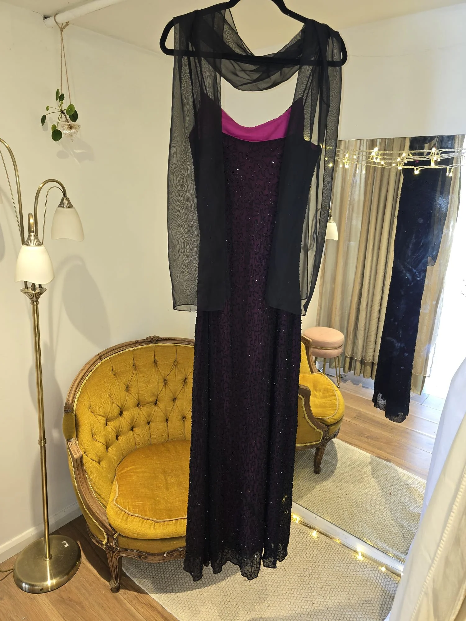 Black floor-length evening gown with sequin detailing and draped neckline, pinned and prepped for tailoring at Brighton Alterations.