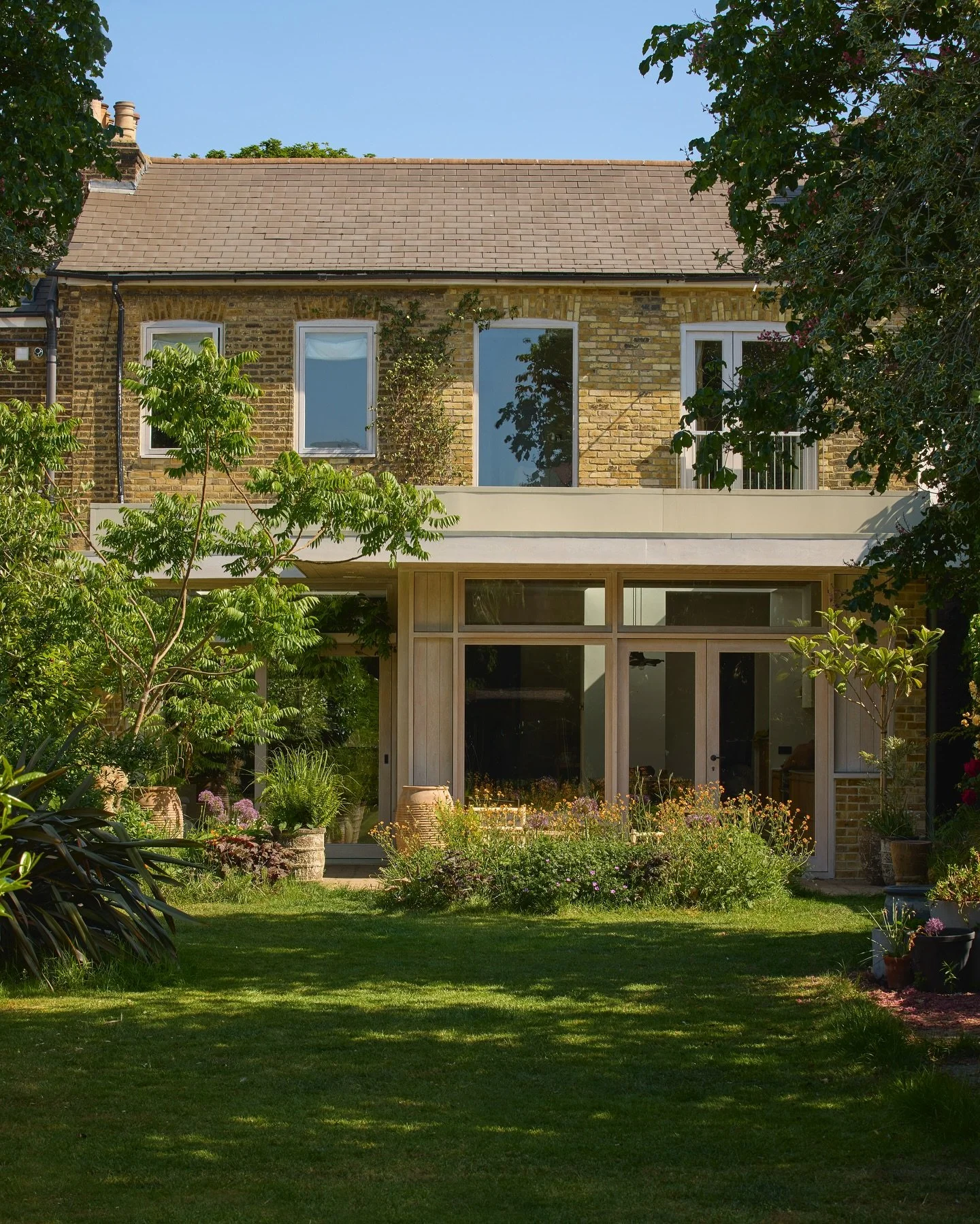 Spot the difference.

Same tree, same baby (ish), a few years on &mdash; and the garden&rsquo;s finally starting to feel like part of the house.

The timber frame was our first step in bridging inside and out &mdash; materiality, on repeat.
Now the p