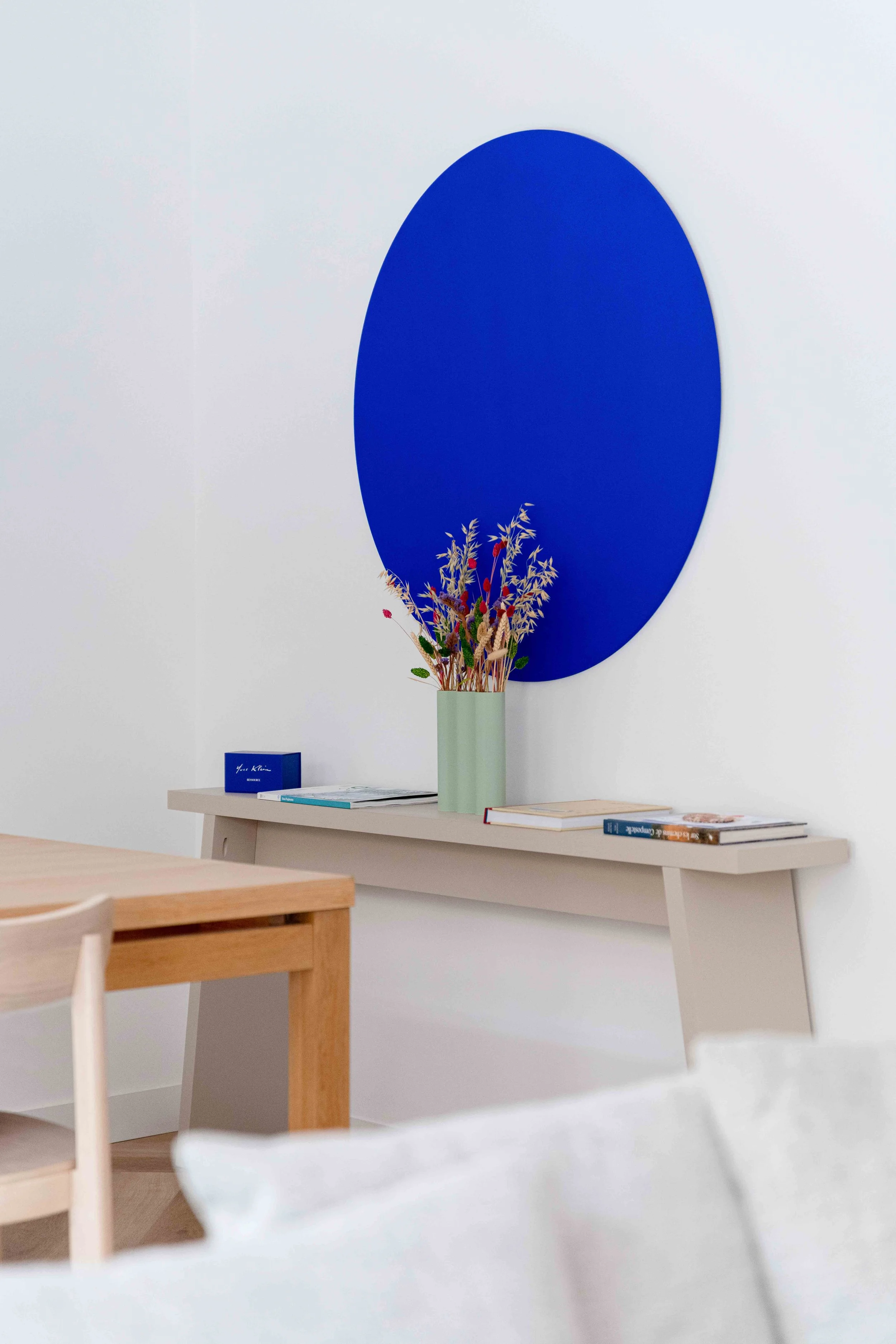 Décoration composée d'une console murale, peinture monochrome bleu Yves Klein et mobilier en bois dans la maison Uchi à Toulouse.