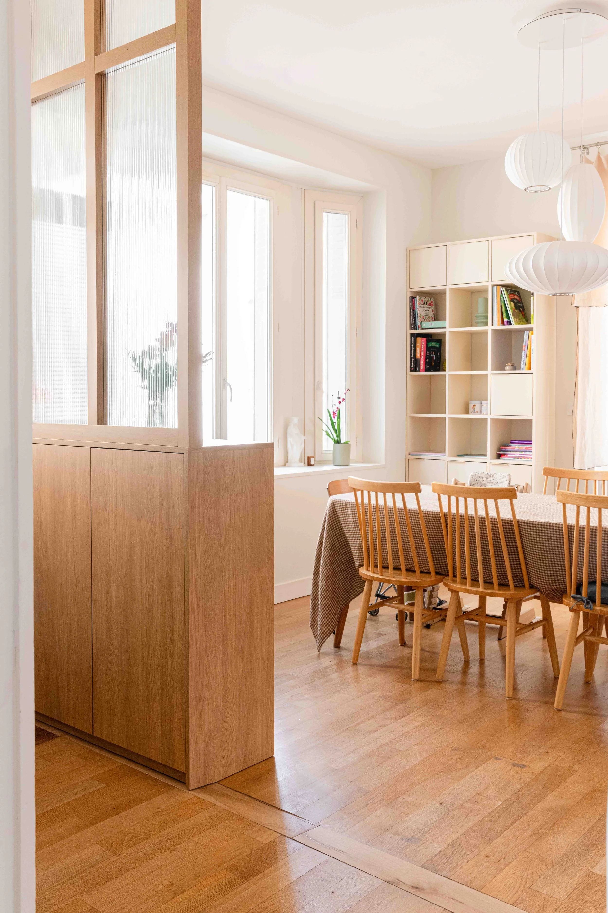 Séparation douce entre entrée et séjour grâce à une cloison vitrée intégrée dans un meuble dessiné sur mesure. Cette intervention, réalisée dans le cadre de la rénovation de la maison l’Agly par Atelier Kiso, illustre un travail minutieux de structur