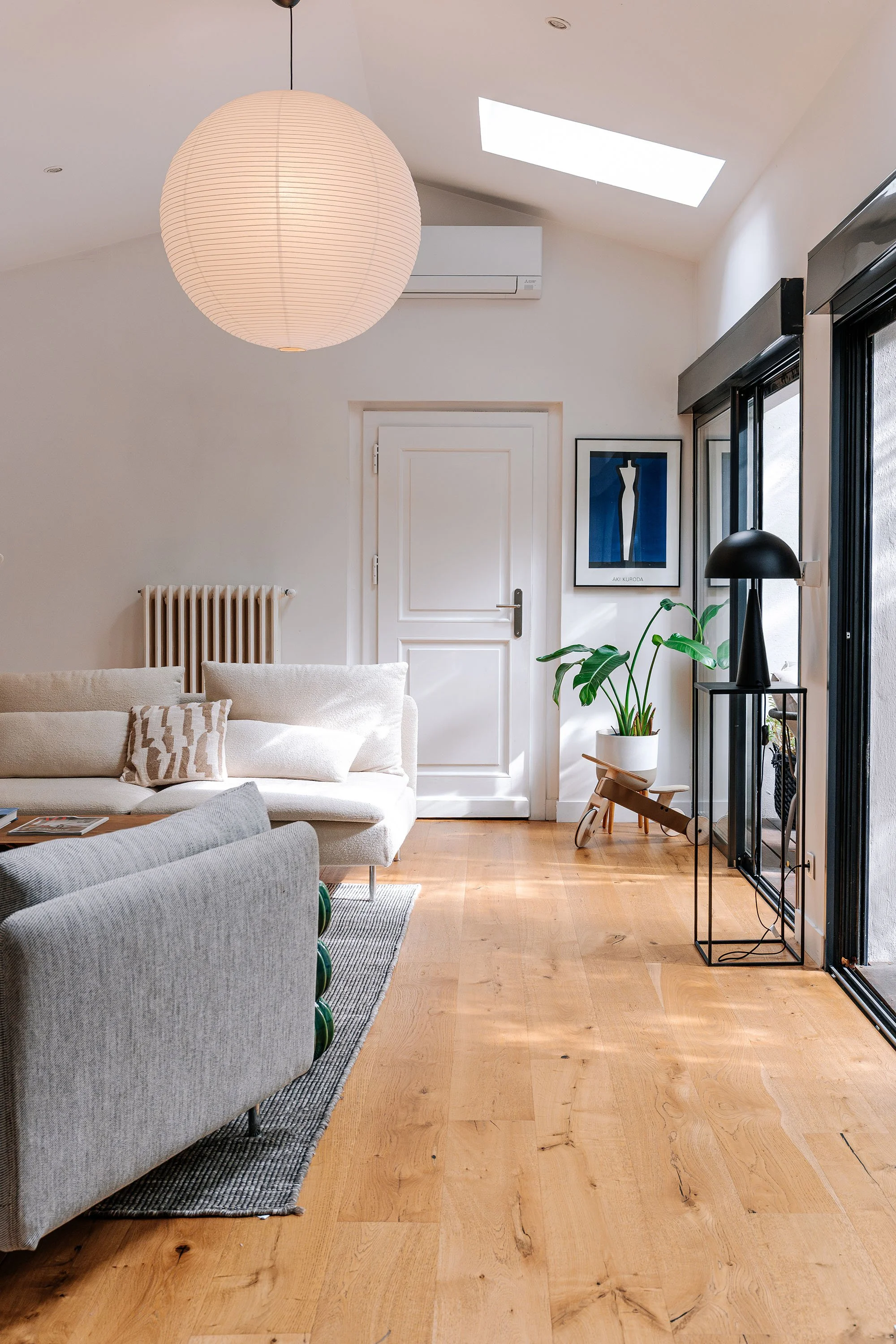 Séjour baigné de lumière grâce à une verrière de toiture et de larges baies vitrées. Une extension discrète qui privilégie les volumes, les vues et le confort d'usage.
