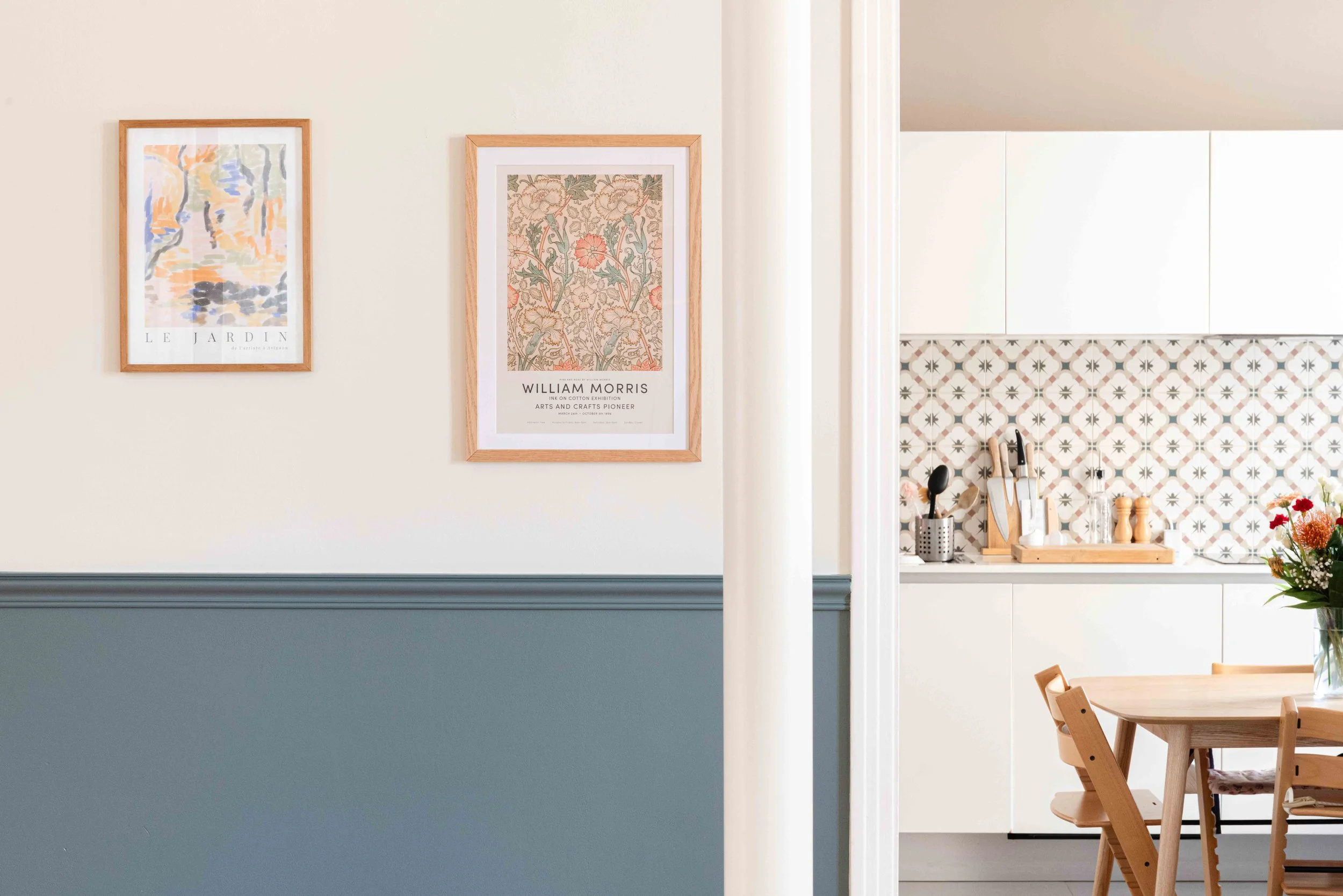 Vue intérieure vers la cuisine. Le jeu de contrastes entre carrelage graphique, mobilier bois clair et soubassement coloré met en valeur notre sensibilité pour chaque détail. Un exemple d’intervention fine et sensible dans un projet de rénovation de
