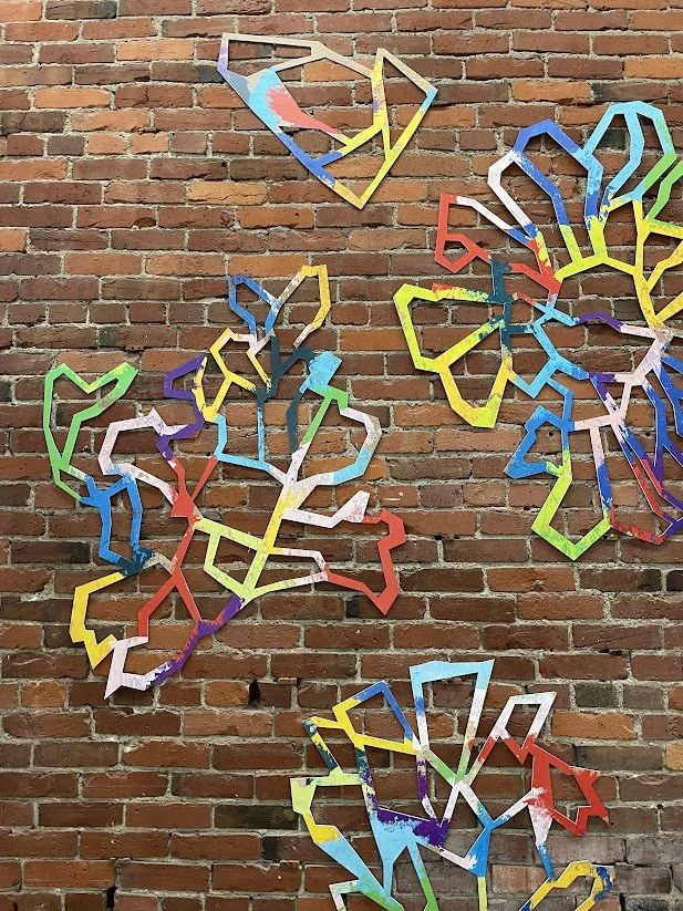 Detail view of Wild Flowers installed on a brick wall at Slip Gallery in Seattle.