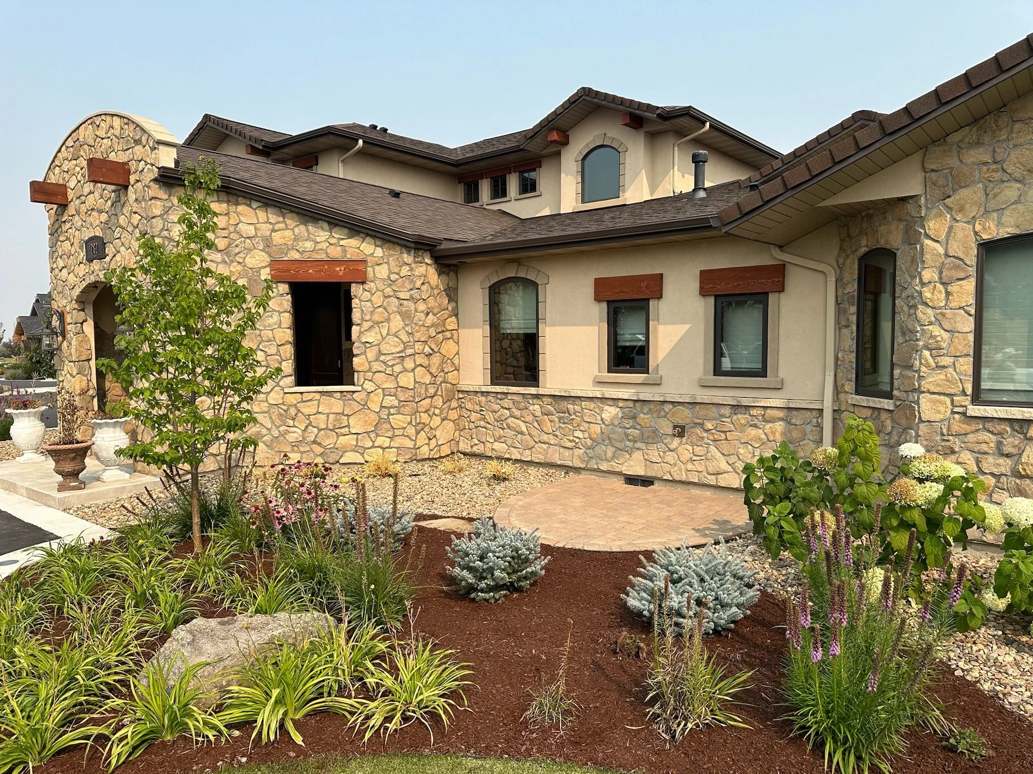 Luxury landscaping bed with a small custom paver patio area -installed in Bozeman