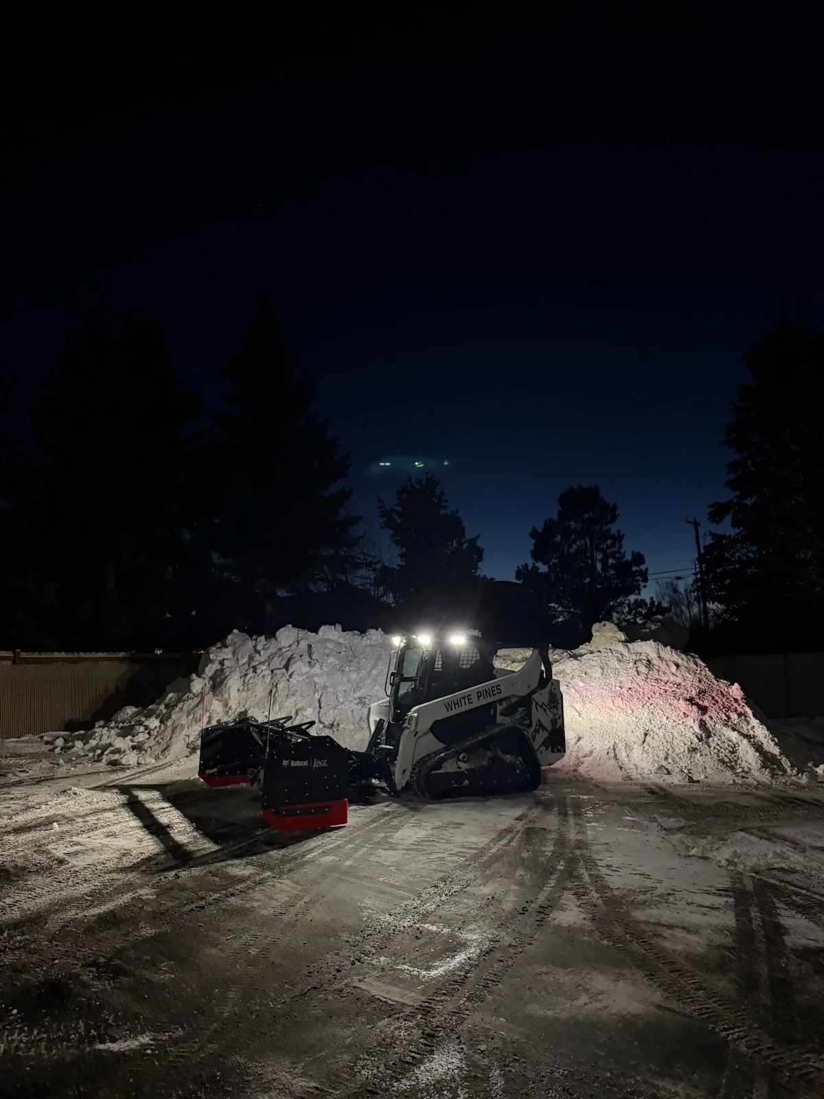 Snow management in Bozeman, Montana - a skid steer compressed a snow pile to take up less space in a parking lot.