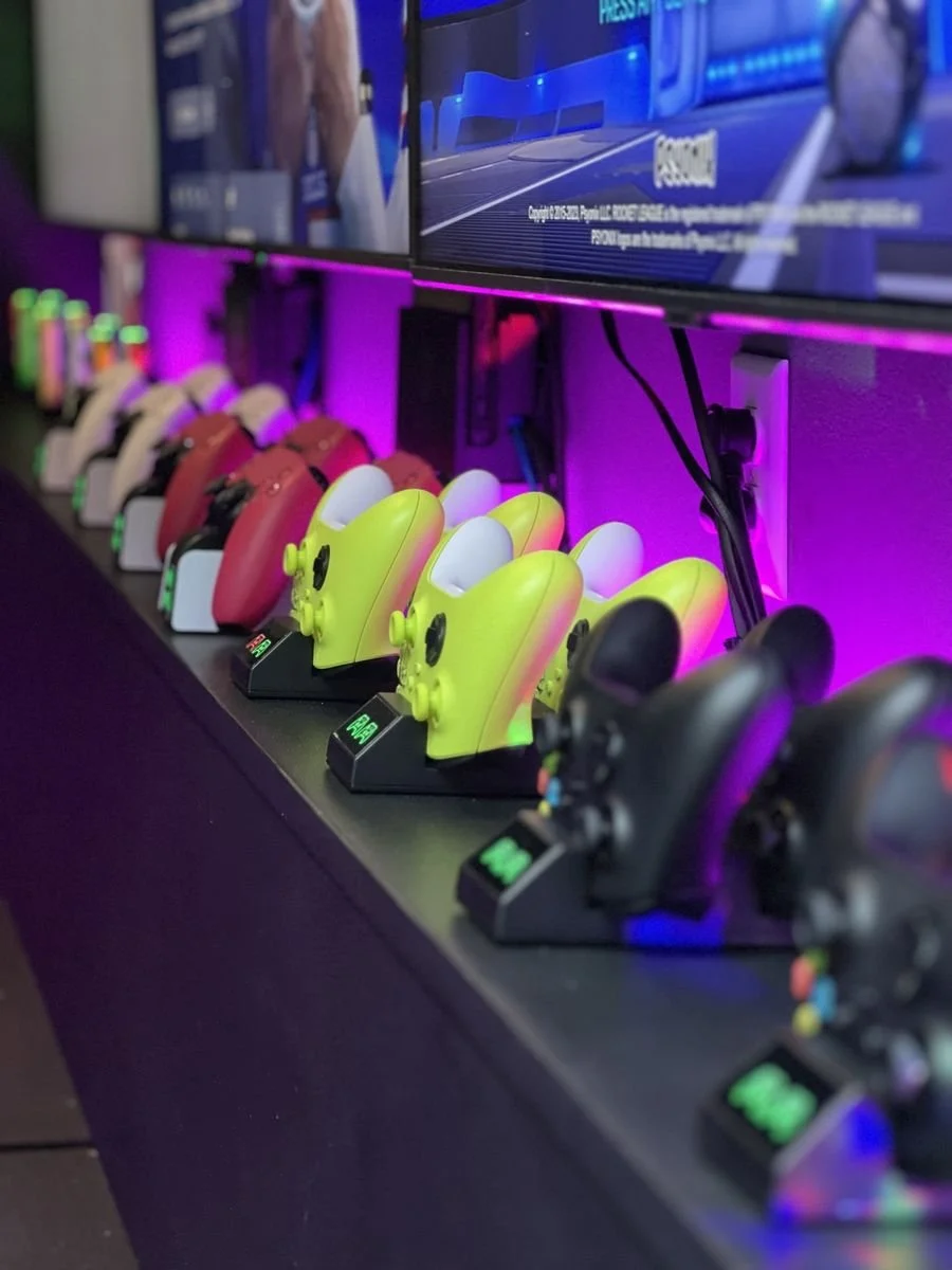 PS5 controllers and Xbox controllers charging in the mobile gaming truck before a birthday party
