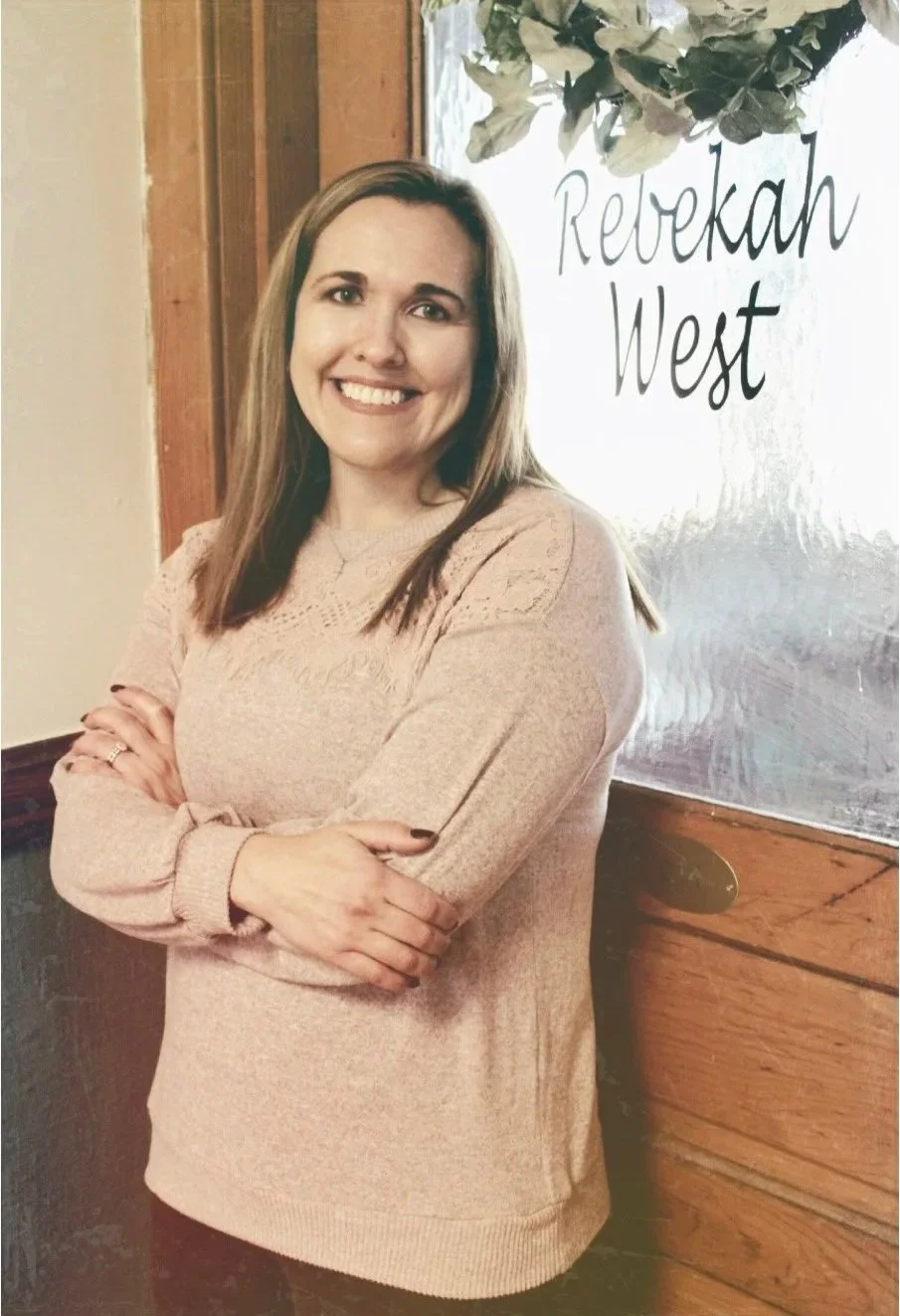 Rebekah West | Therapist in OH | Rebekah standing in front of an office door and smiling