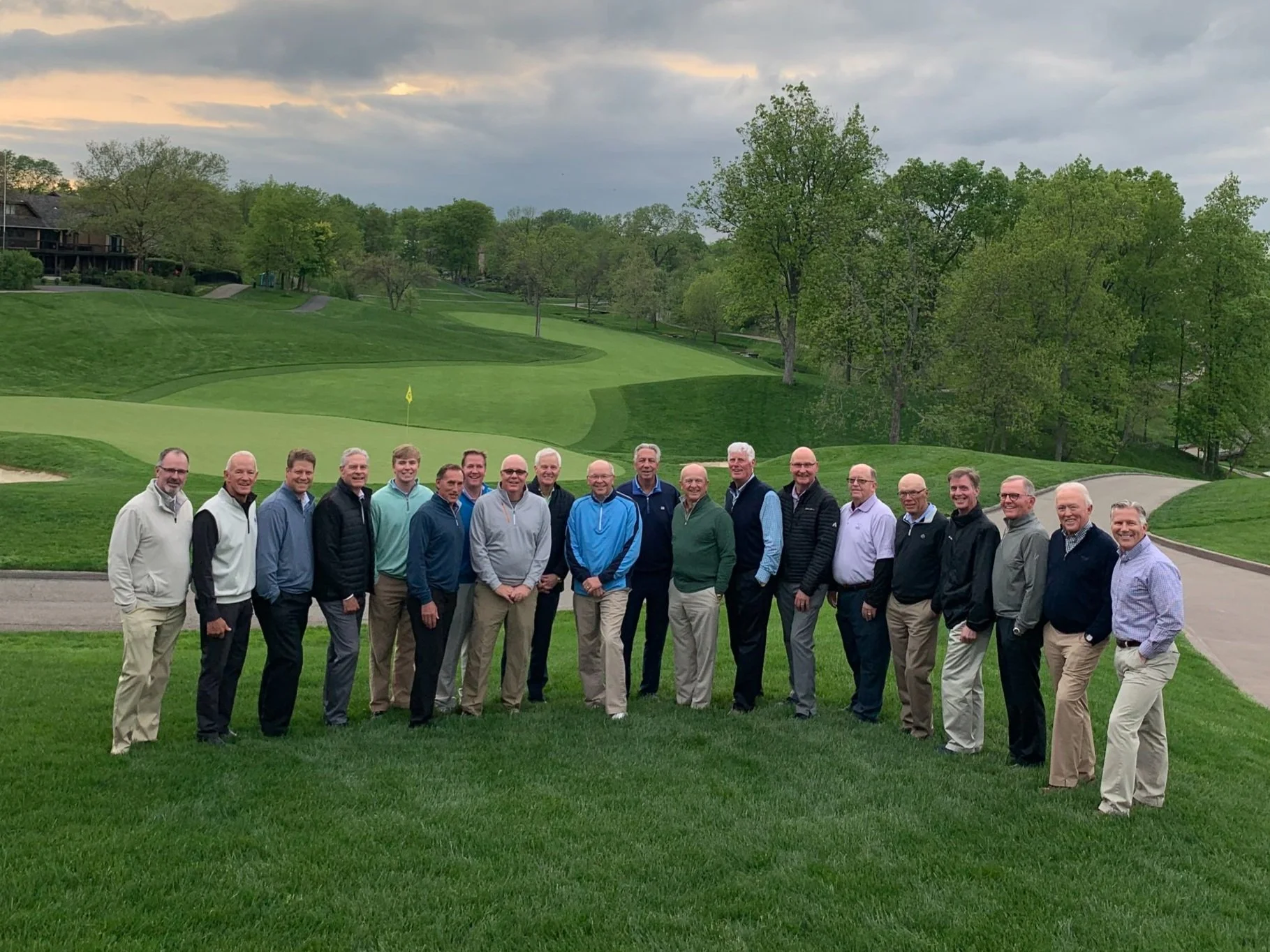 Small group of donors gathered on the fairway during a charity golf event – relaxed moment on course before or after tournament play.