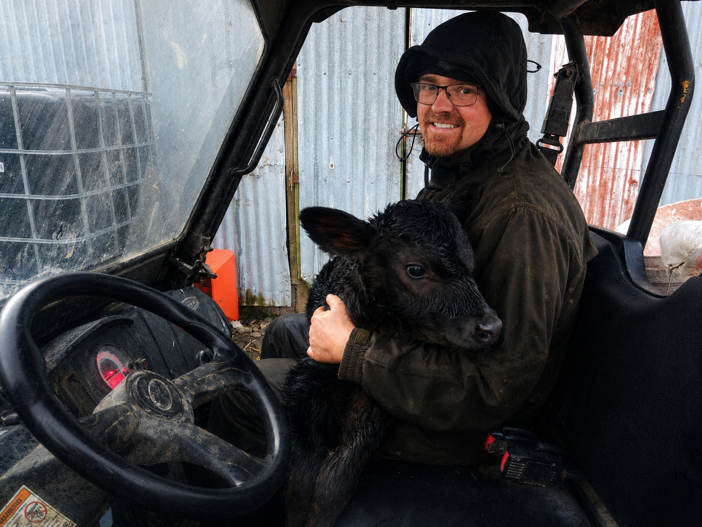 Scott holding a calf during his dairy farming years