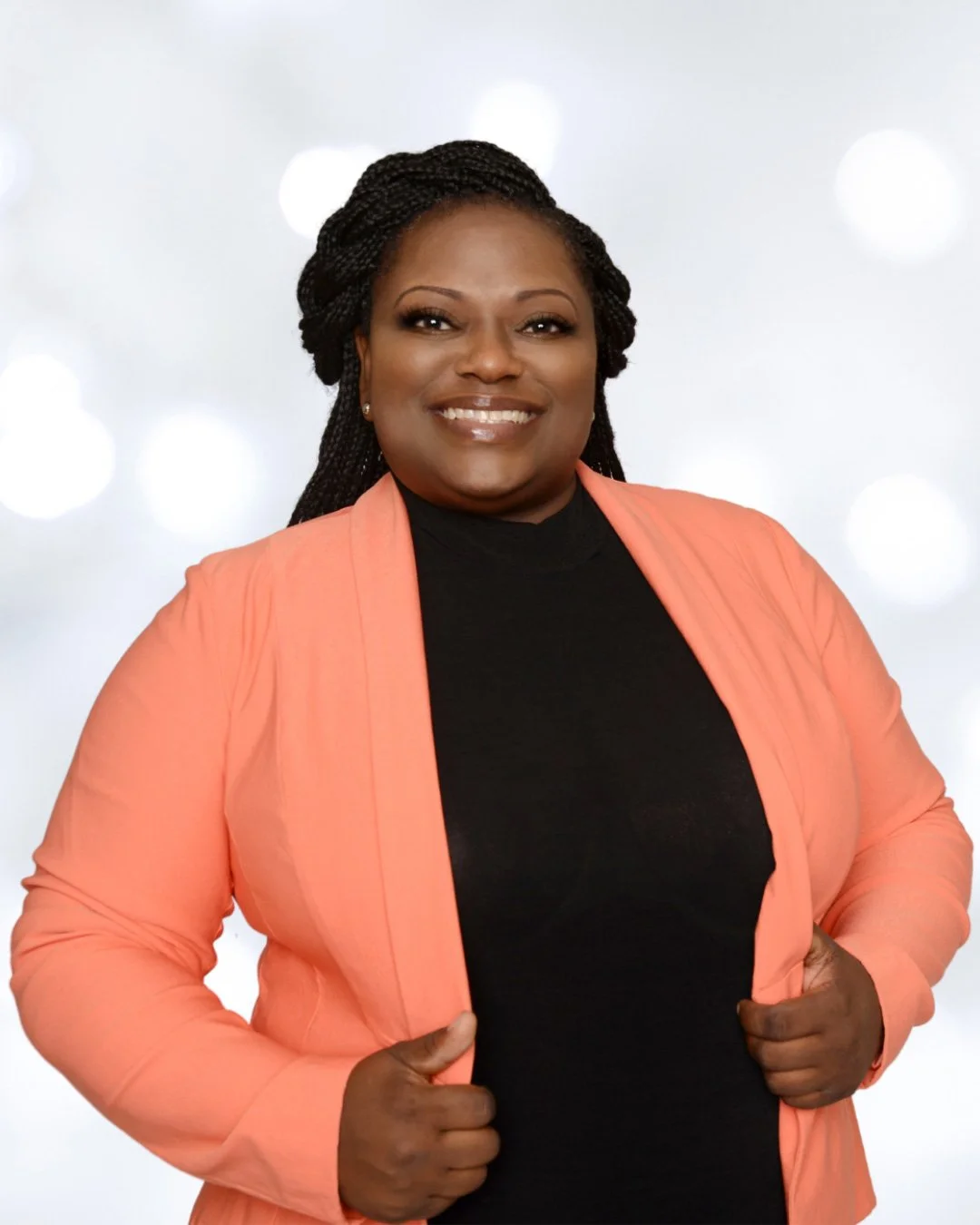 Deep in Faith Founder Kimberly Jackson stands in orange jacket smiling