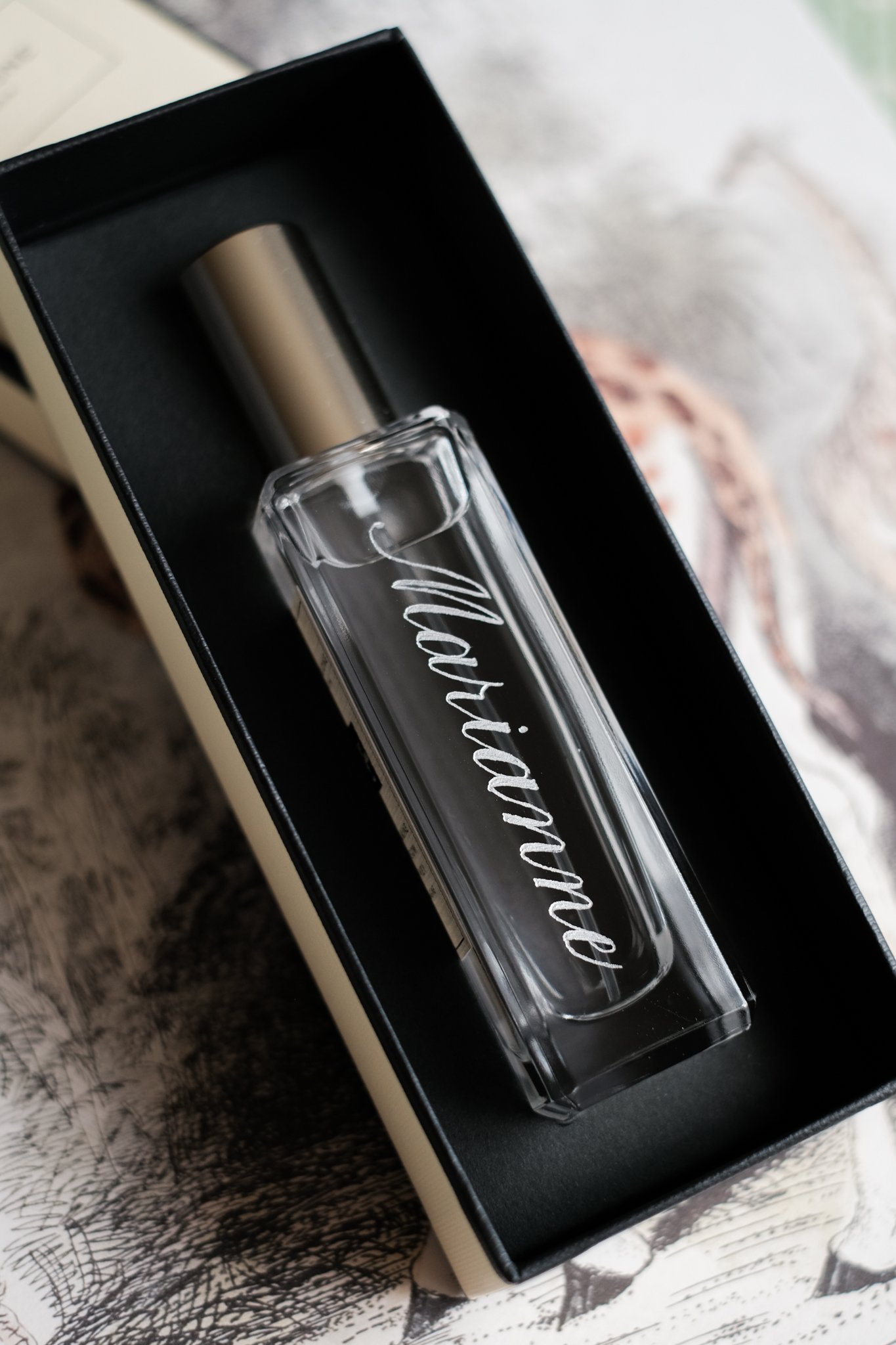 Hand calligraphy engraving on jo malone perfumes with the name marianne in copperplate calligraphy