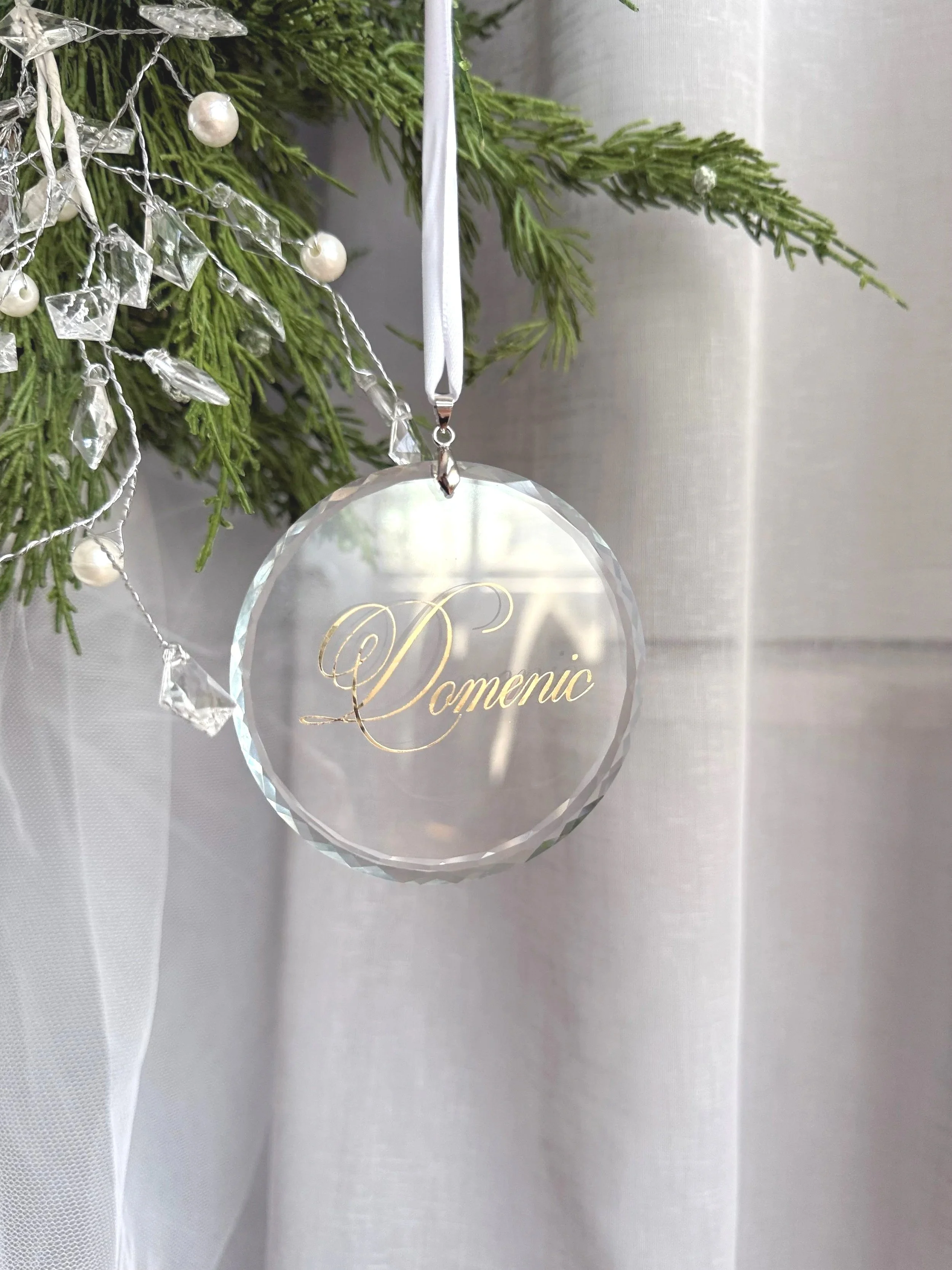 Personalised crystal Christmas ornament with custom engraving hanging on a decorated tree