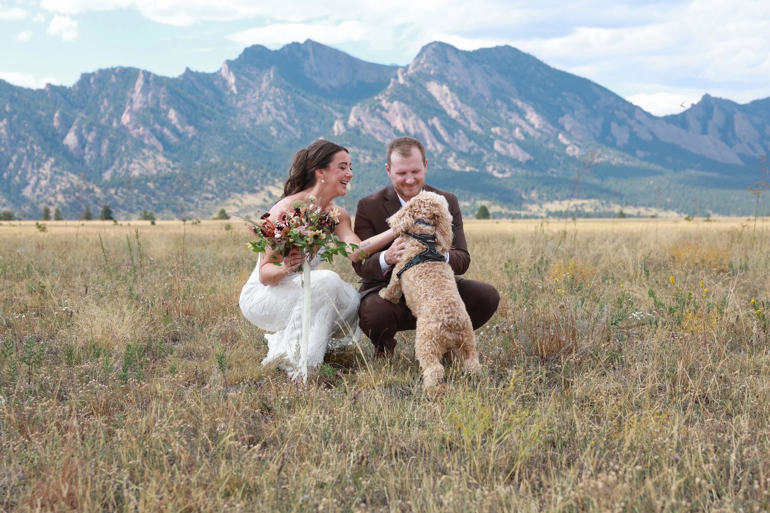 ntimate mountain wedding in Golden, Colorado featuring a bride holding a sunflower bouquet and the couple's dog.