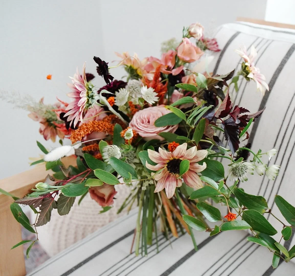 This Fall bride knew she wanted sunflowers but instead of traditional yellow, we designed her bouquet with a Strawberry Blonde variety, set among warm shades of dusty rose, burgundy, and rust for a bouquet that danced among the mountain backdrop. 

2