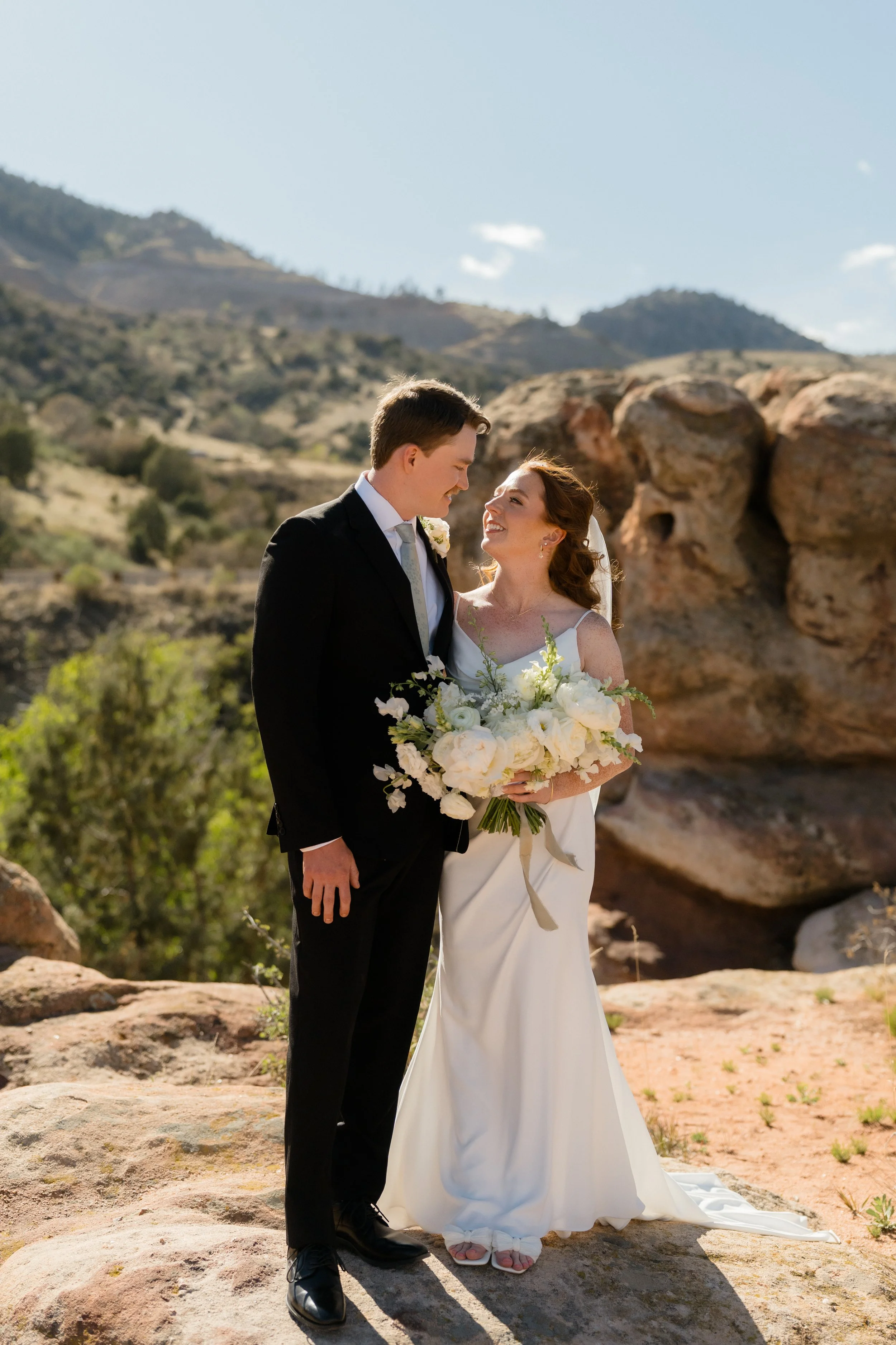 [Bride and groom exchanging vows] at an outdoor [Castle Rock] venue with sweeping views of the [Rocky Mountains] in Colorado.