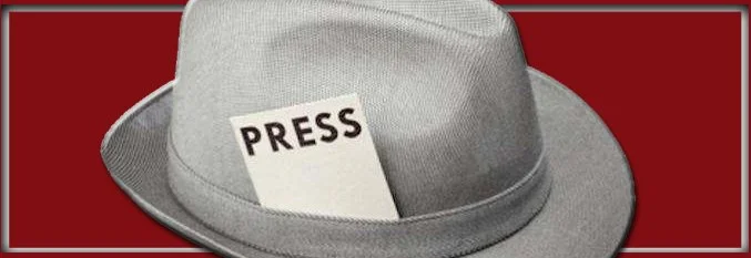 Gray fedora hat with a press pass tucked inside