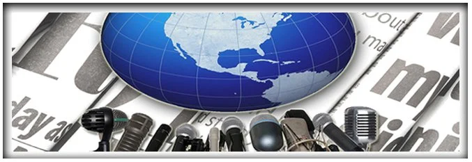 Close-up of a row of microphones on a surface with newspaper in the background, and a globe showing North and Central America placed above the microphones.