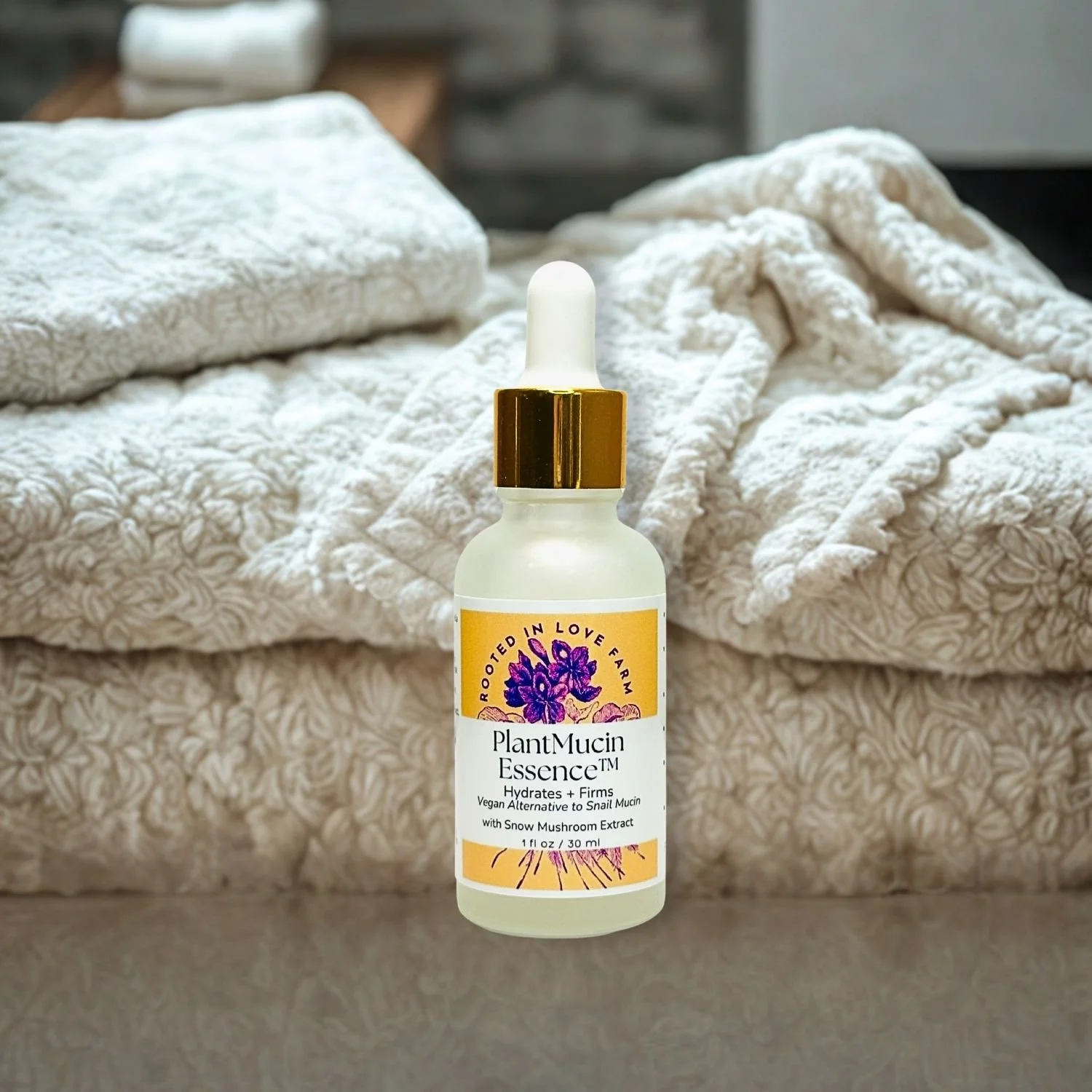 PlantMucin Essent by Rooted in Love Farm with Snow Mushroom Extract on white background with soft towels in bathroom.jpg