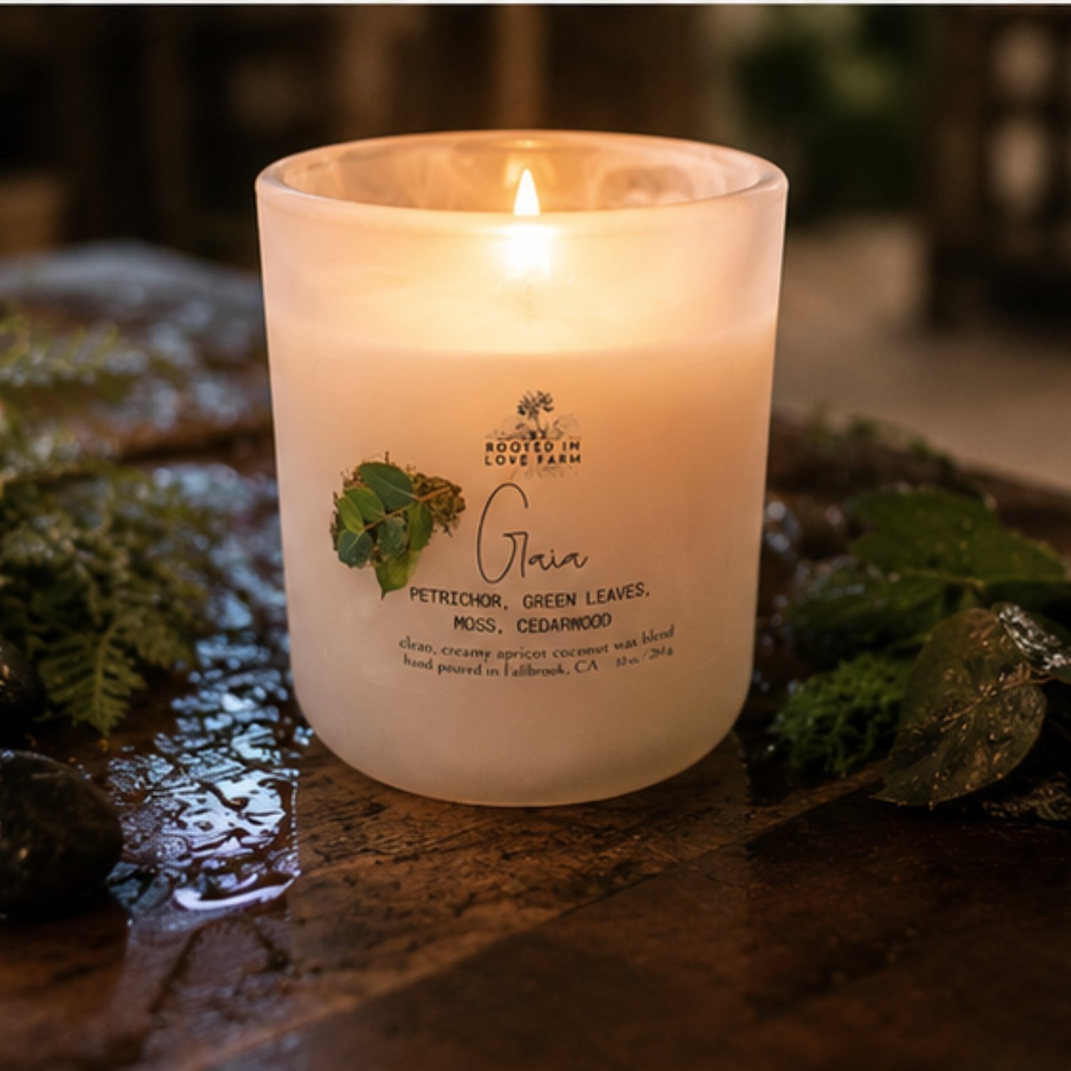 Gaia 10 oz lit on wooden table with greenery.jpg