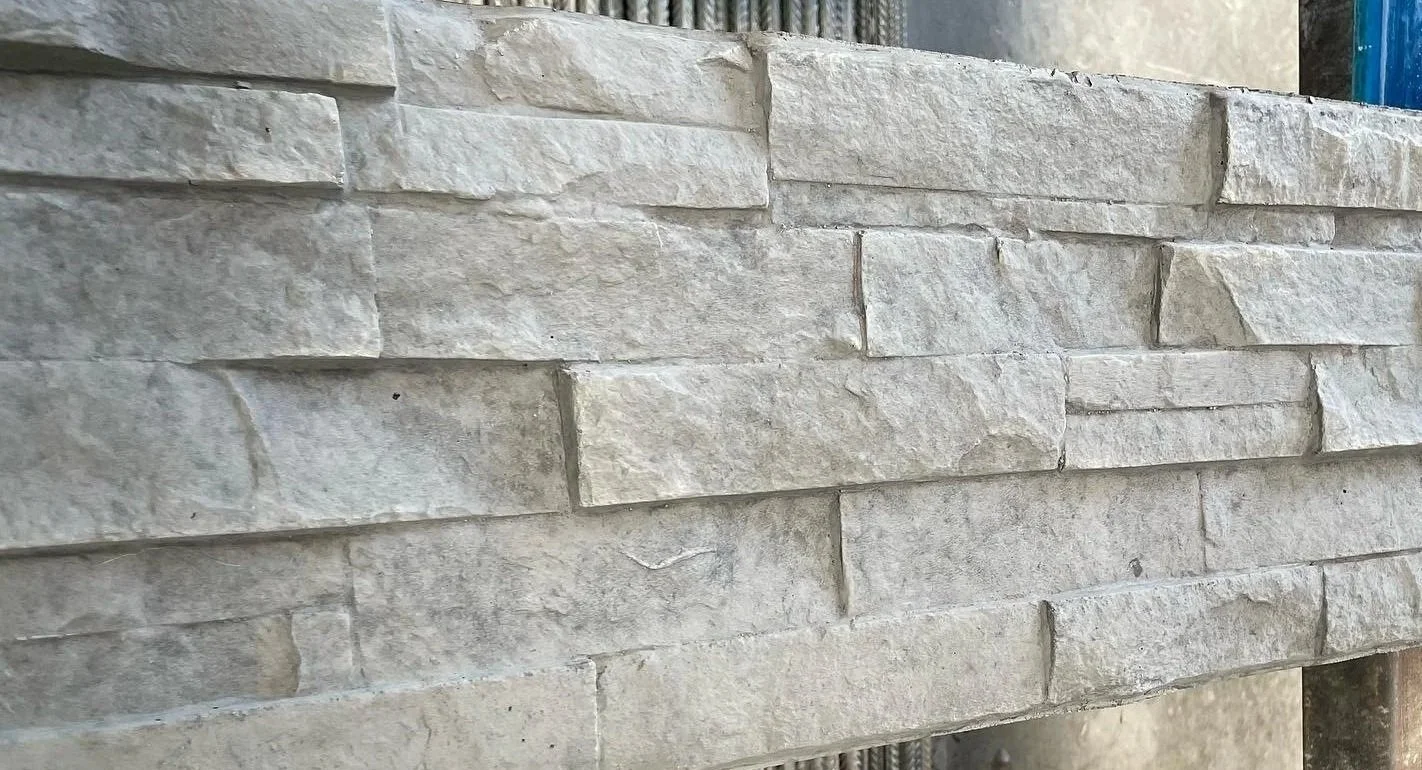 Close-up of stacked beige stone bricks in a wall with a rough texture.