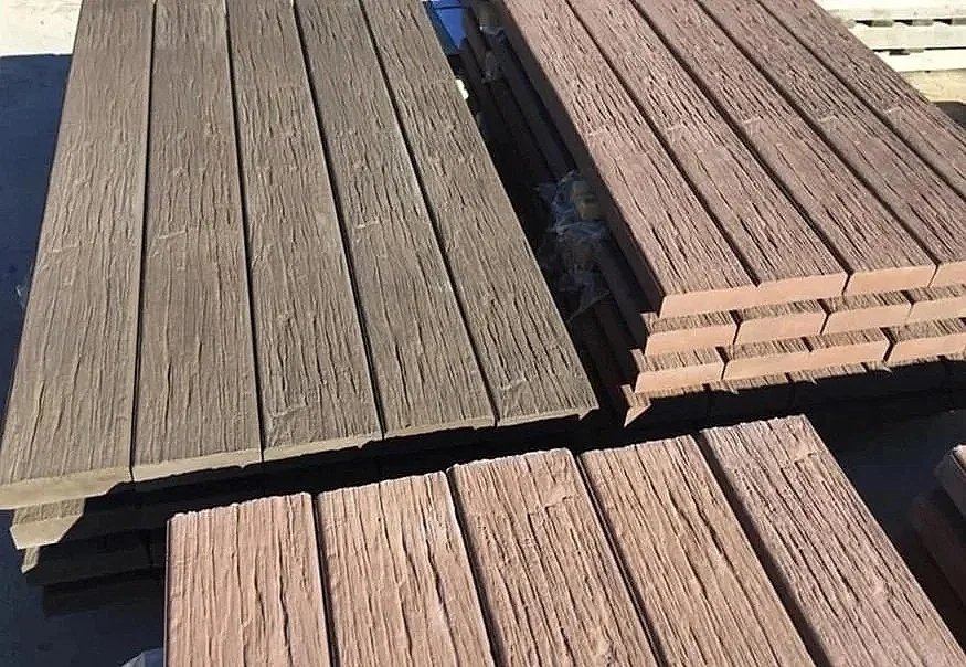 Stacks of wooden planks arranged on a surface, with some in light brown and others in darker brown color.