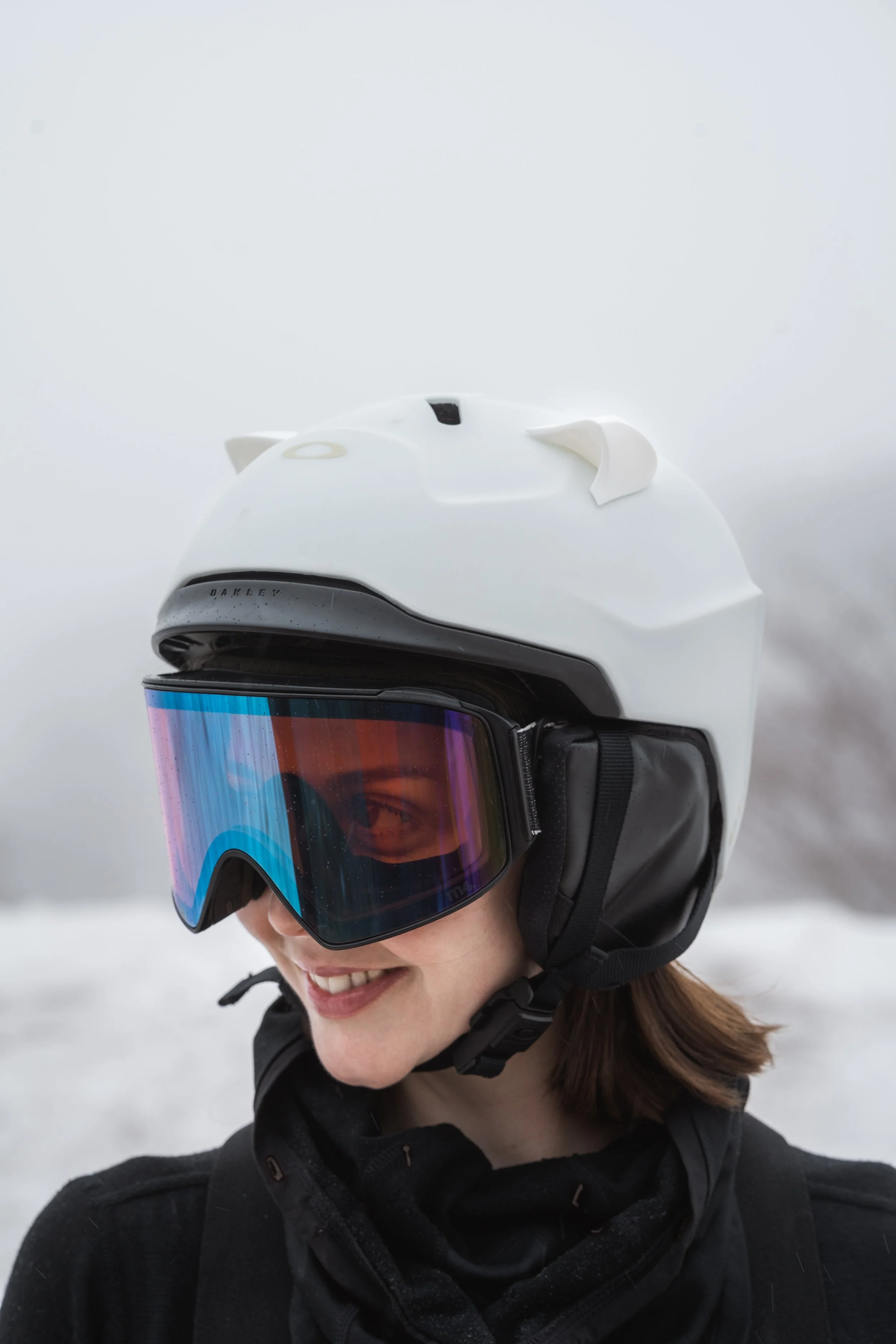 White snowboard helmet with 3D printed cat ears on a snowy mountain