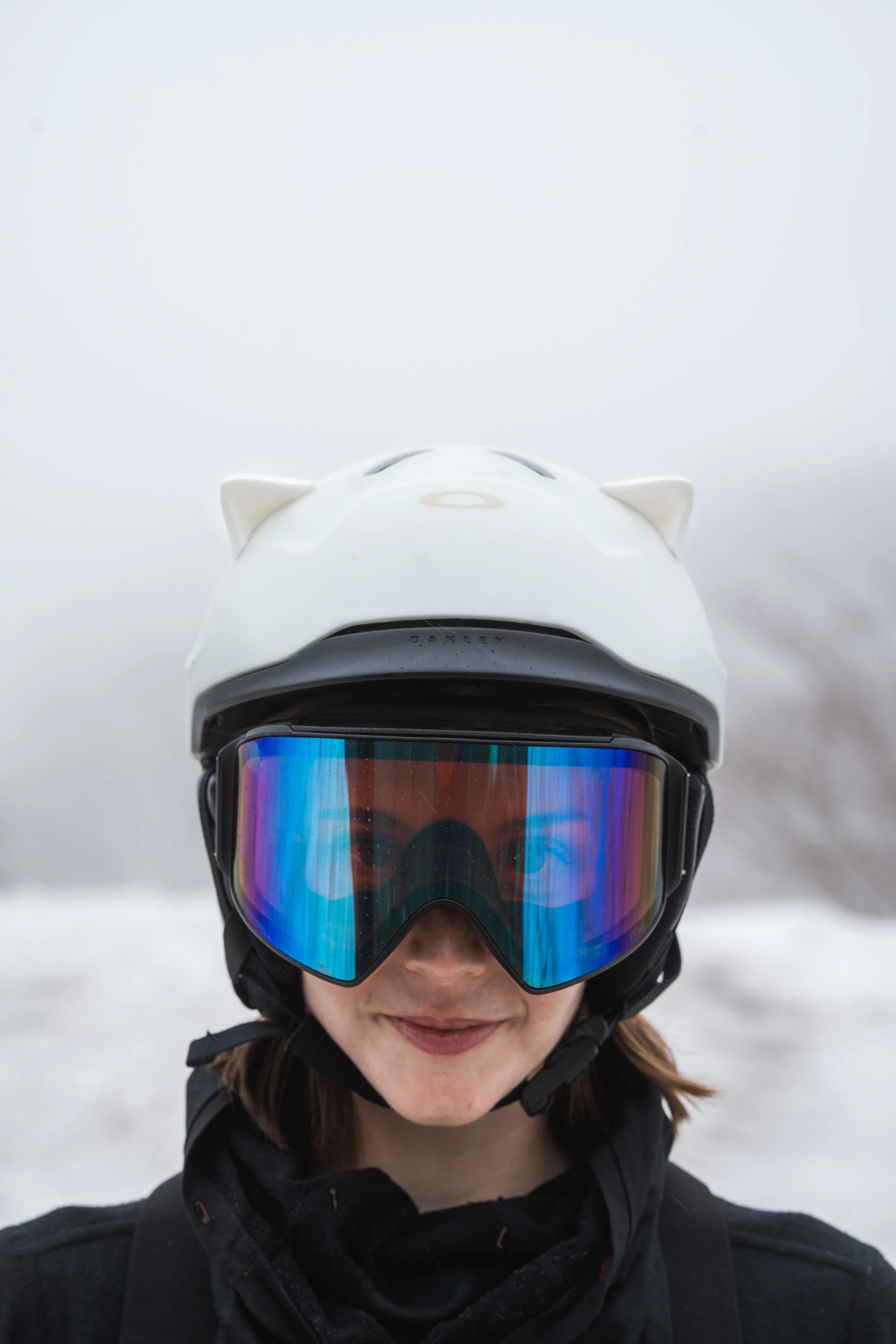 White snowboard helmet with 3D printed cat ears on a snowy mountain