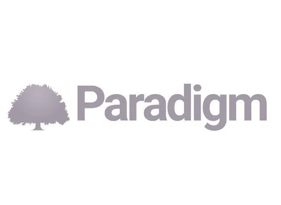A logo featuring a gray tree silhouette and gray text.