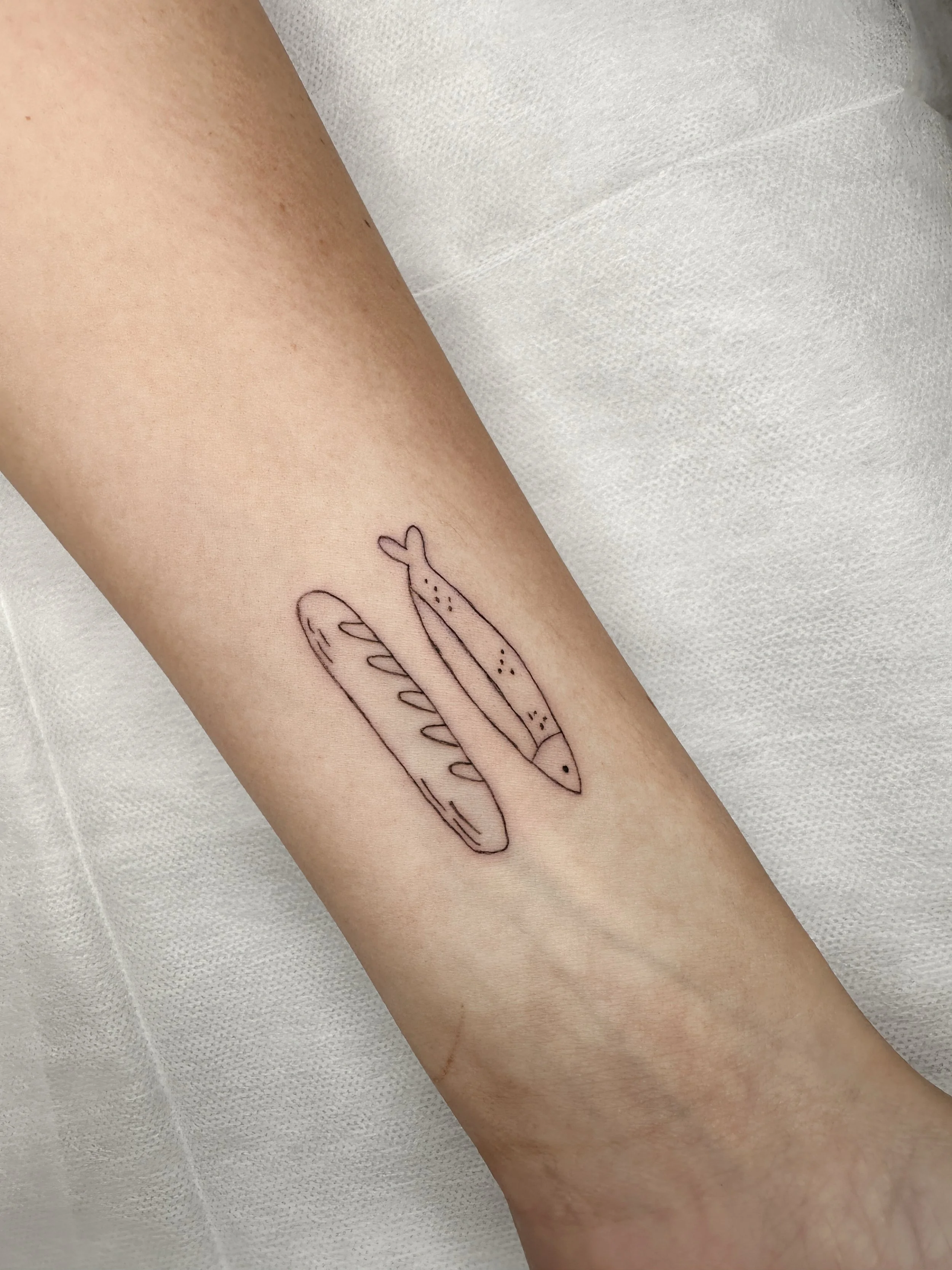 Loaves and fishes 🐟🥖 A little symbol with a big story.

Fine line tattoo work done right here in Chattanooga &mdash; delicate detail, deep meaning. 🖤

Ready for a tattoo that tells your story? DM me to book your fine line session at Wild Violet St
