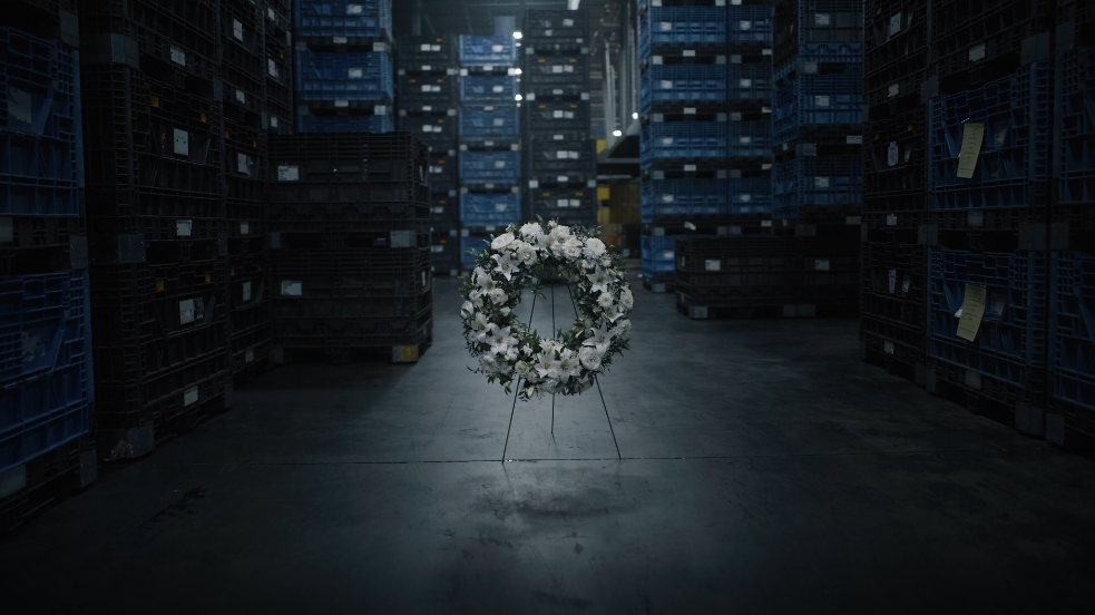 WSIB Day Of Mourning Ad featuring a funeral Wreath in a warehouse