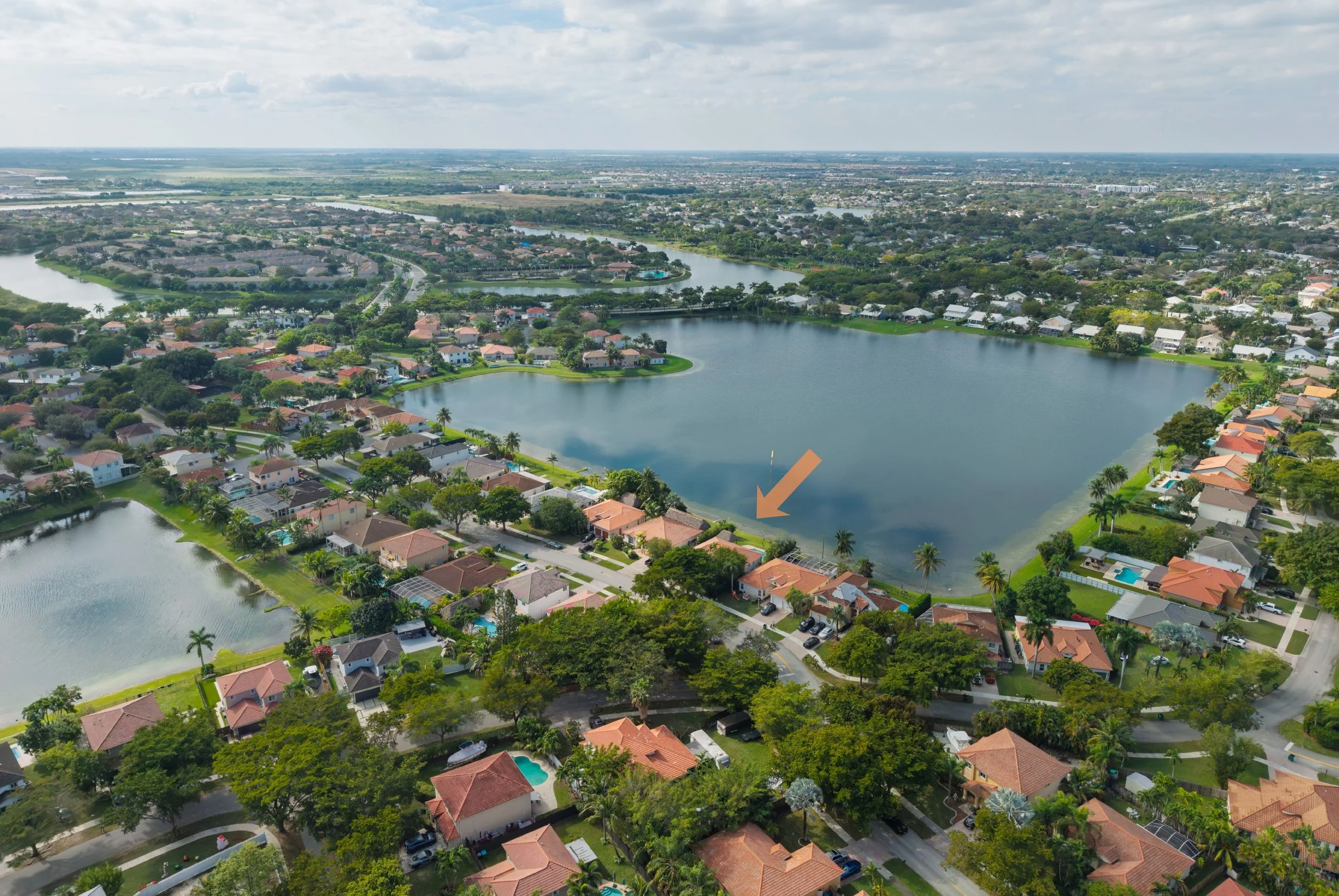 Aerial view of the Lakes by the Bay community in Cutler Bay, highlighting the home’s lakefront location among winding waterways, lush greenery, and surrounding residential streets.