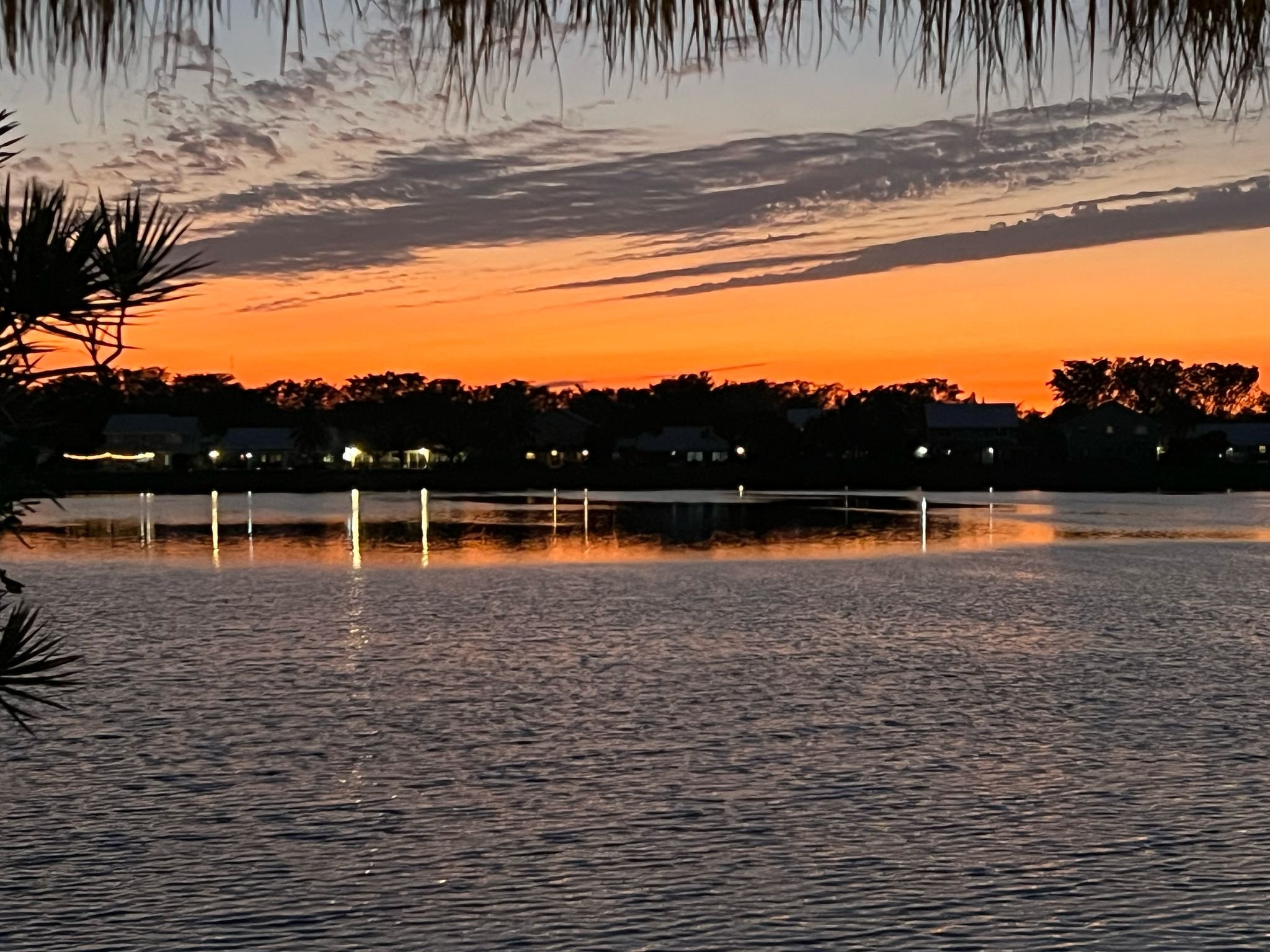 Sunset view over the lake with calm water reflecting orange and blue skies, seen from a waterfront home in Cutler Bay.