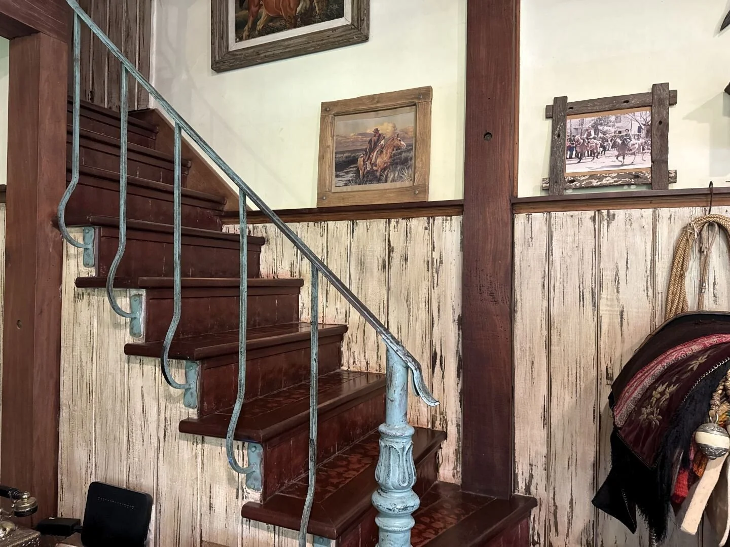 Rustic wooden staircase with iron railing and handcrafted details inside Casa Ing. Maschwitz.