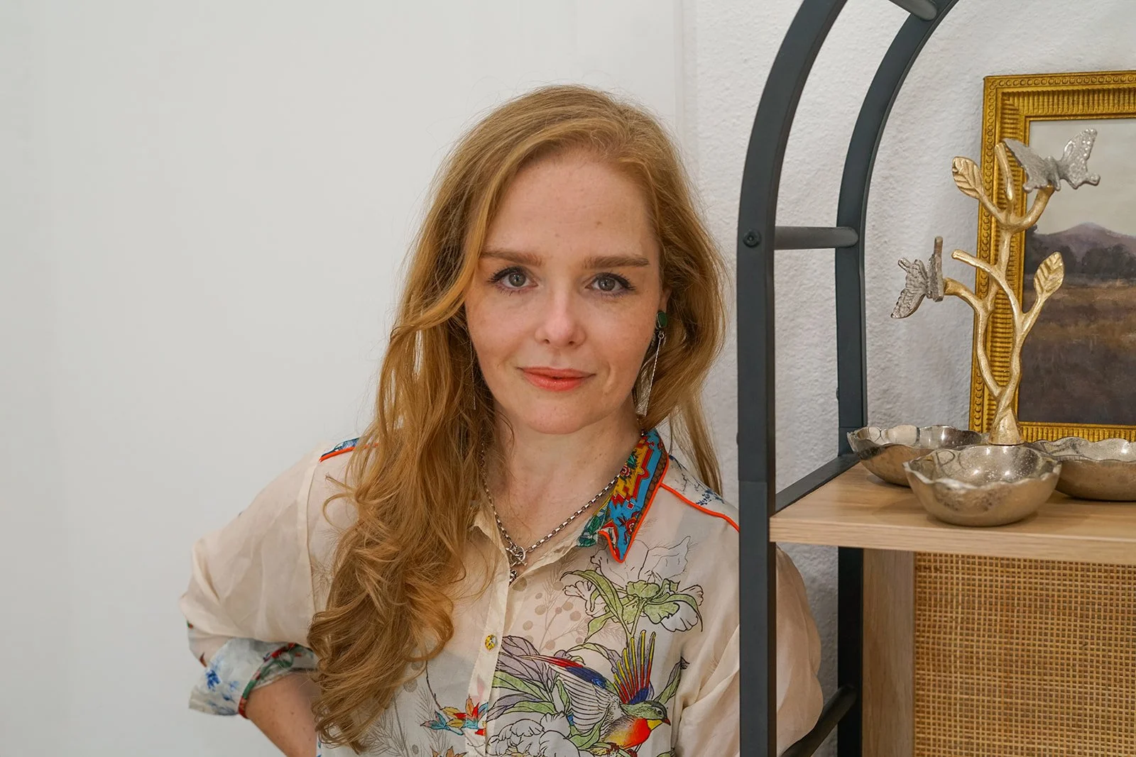 Close-up portrait of a smiling female Austin therapist with long brown hair, wearing a striped blouse and gold necklace, photographed outdoors at sunset — representing warmth, compassion, and trauma-informed grief counseling in Austin, TX.